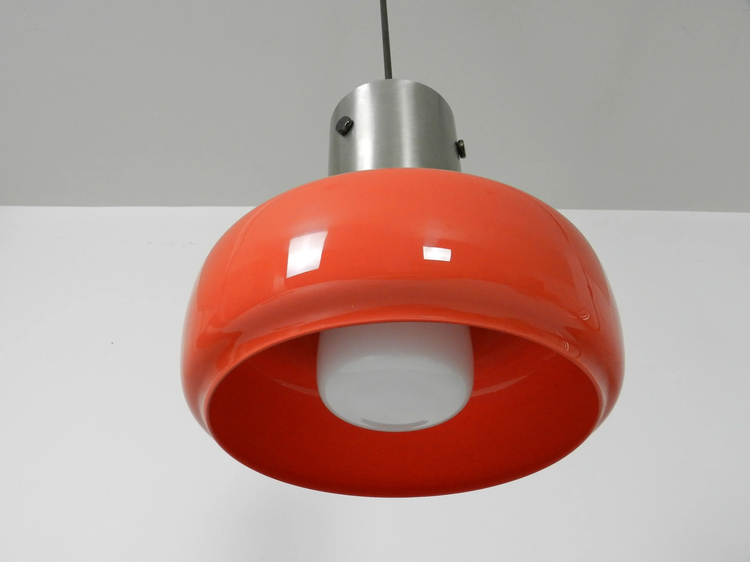 Space age pendant lamp in orange case glass with inner white glass shade and steel hardware.  Italy, 1970s.