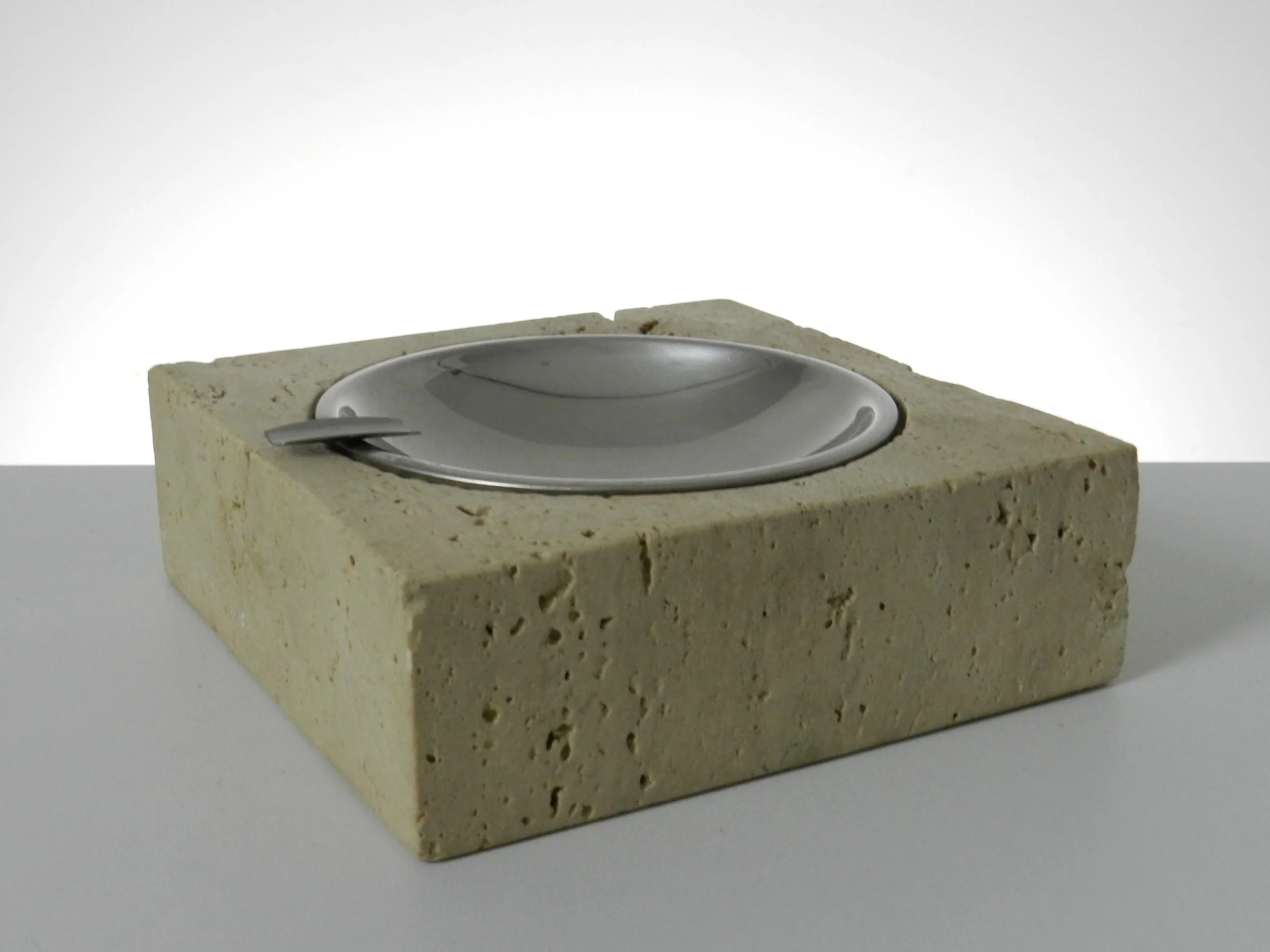 Travertine and stainless steel ashtray designed by Fratelli Mannelli for Raymor.  Italy, 1960s.