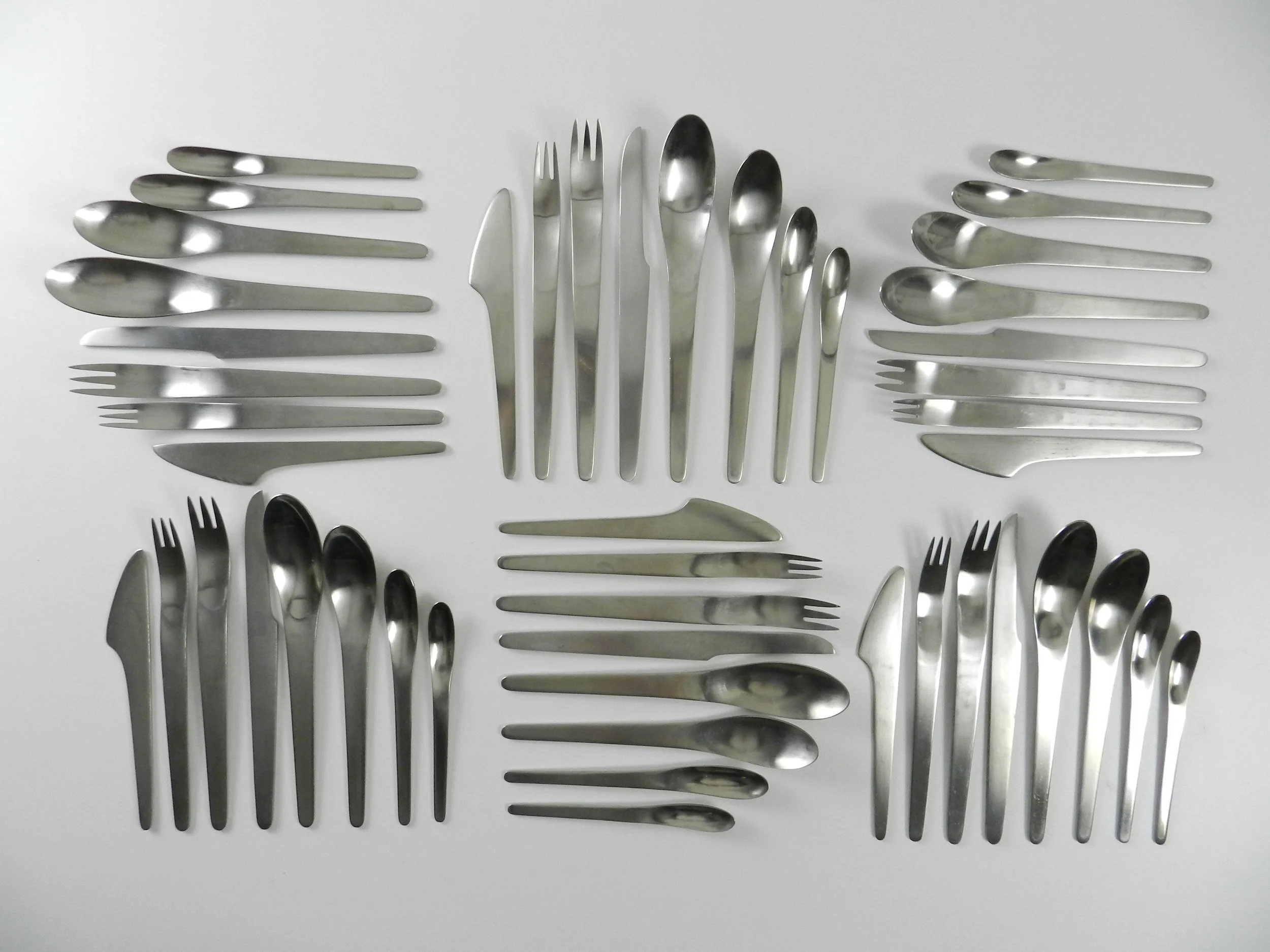 Modernist stainless steel flatware set designed by Arne Jacobsen for A Michelsen.  Denmark, 1960s.