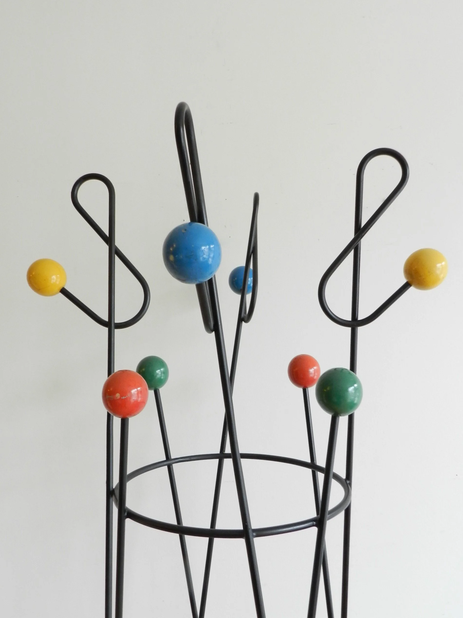 Mid century modern standing coat rack designed by Roger Feraud. Painted iron with lacquered wood balls.  France, 1950s.