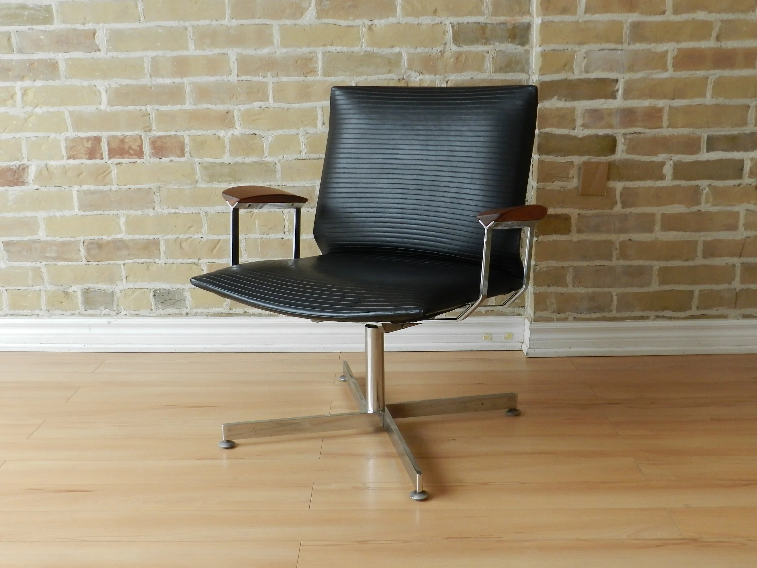 Pair of swivel lounge chairs designed by Walter Nugent. Rare version in chromed steel with ribbed vinyl uphostery and walnut arms.  Canada, 1960s.
