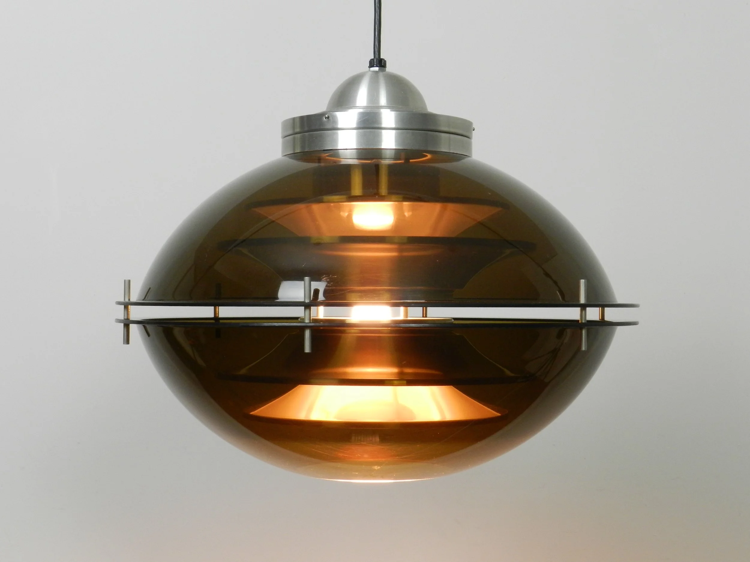 Space age pendant lamp with tinted acrylic outer shell and stacked aluminum plates on the interior by Herda.  Netherlands, 1970s.