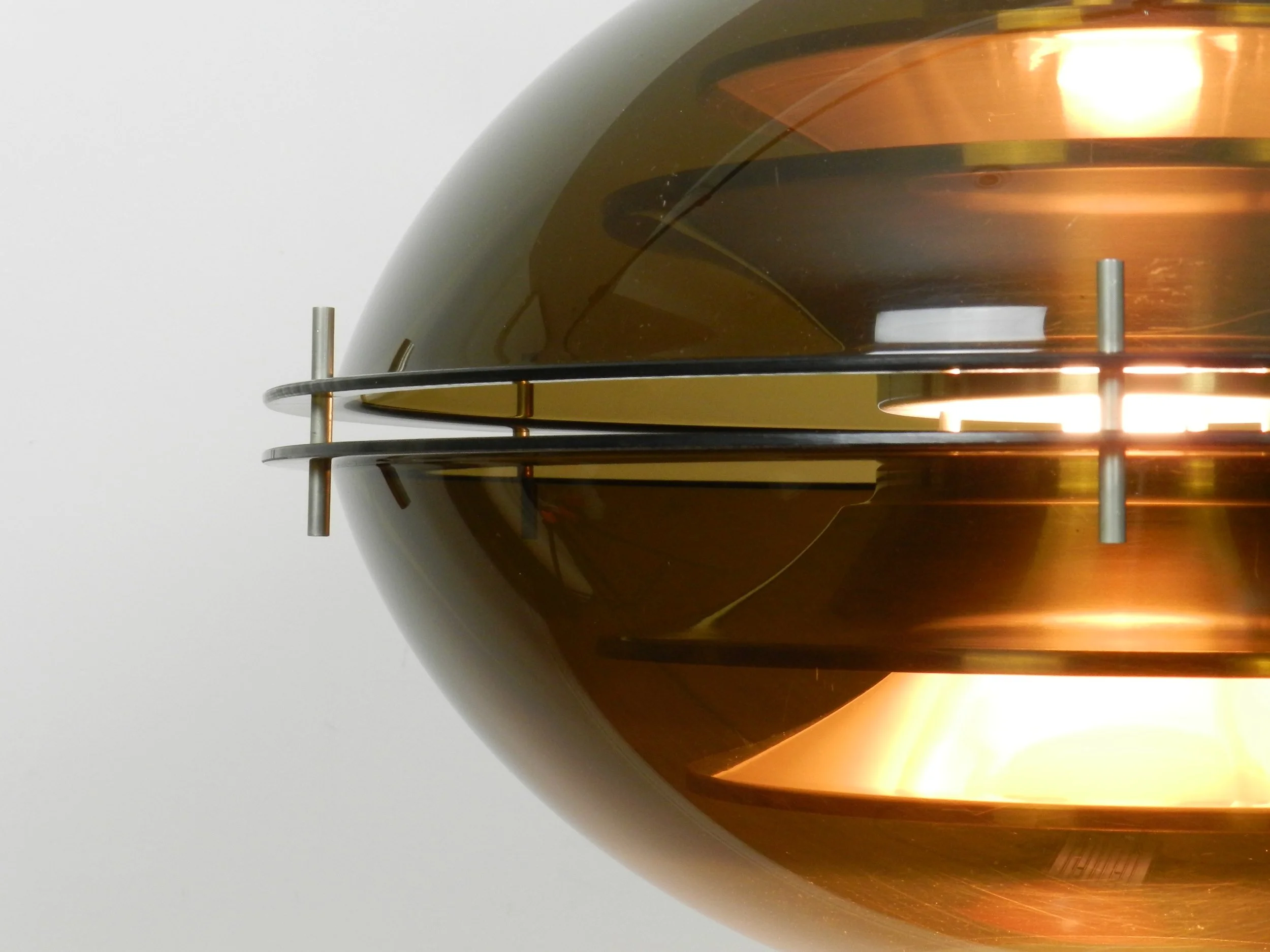 Space age pendant lamp with tinted acrylic outer shell and stacked aluminum plates on the interior by Herda.  Netherlands, 1970s.