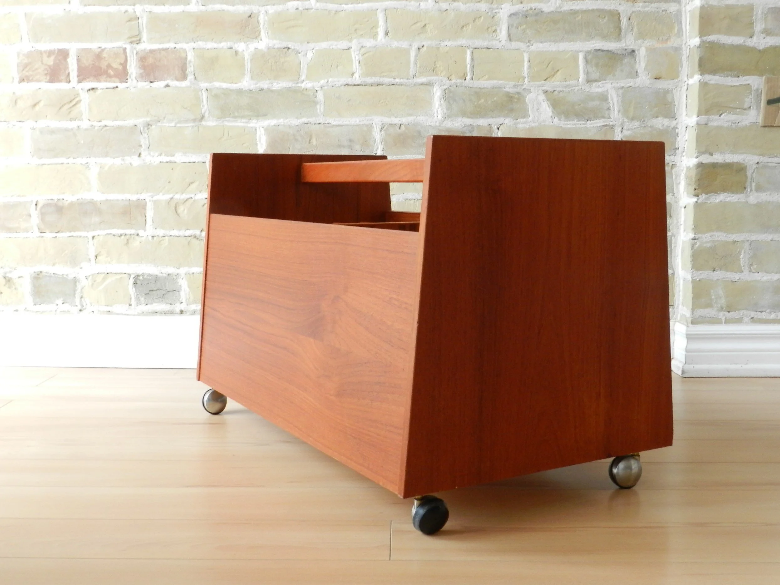 Teak record holder or magazine rack on castors designed by Rolf Hesland for Bruksbo Mobler.  Norway, 1960s.
