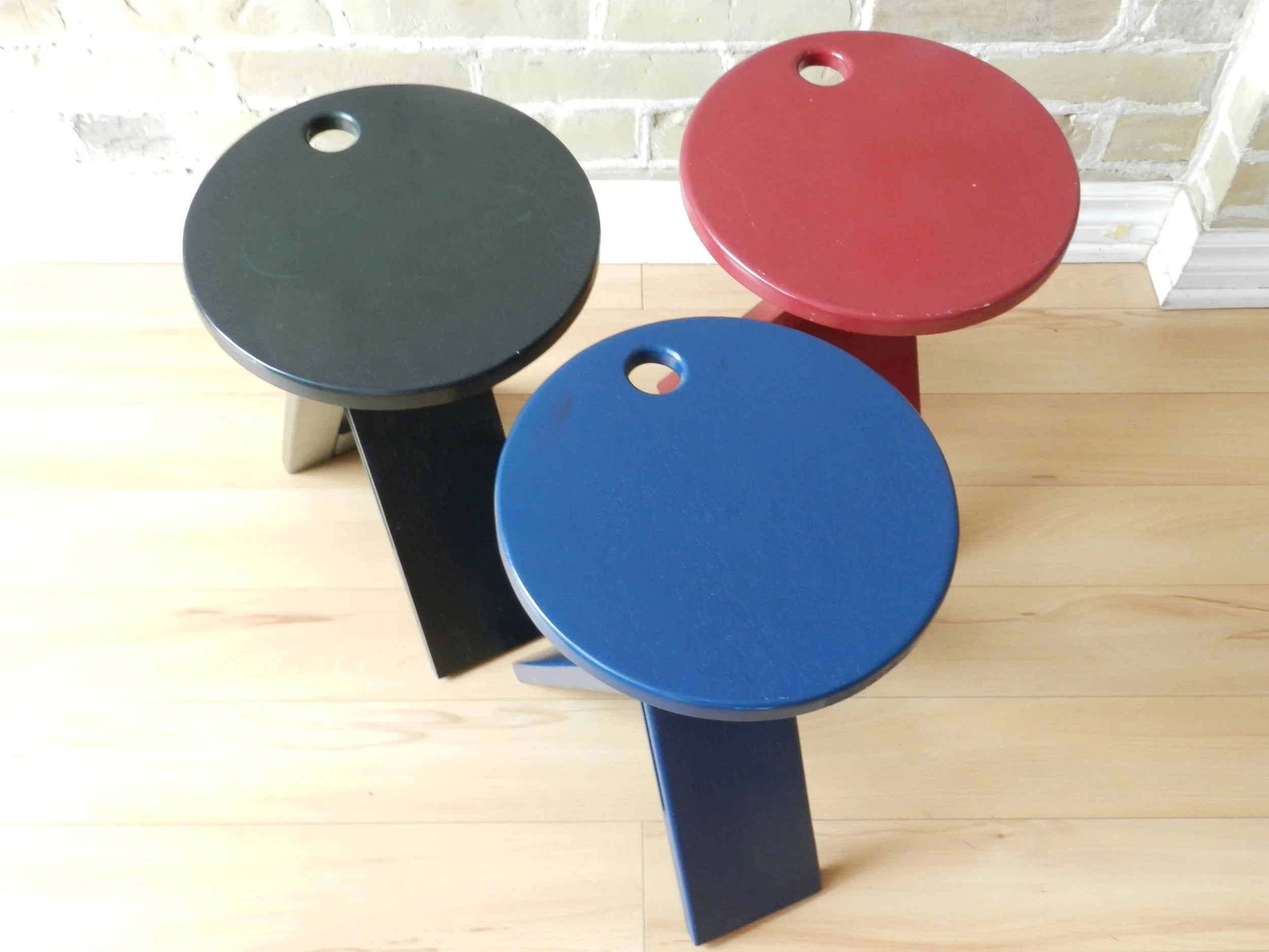 Set of three post modern folding “Suzy” stools designed Adrian Reed for Princes Design Works. Lacquered Wood.  United Kingdom, 1984.
