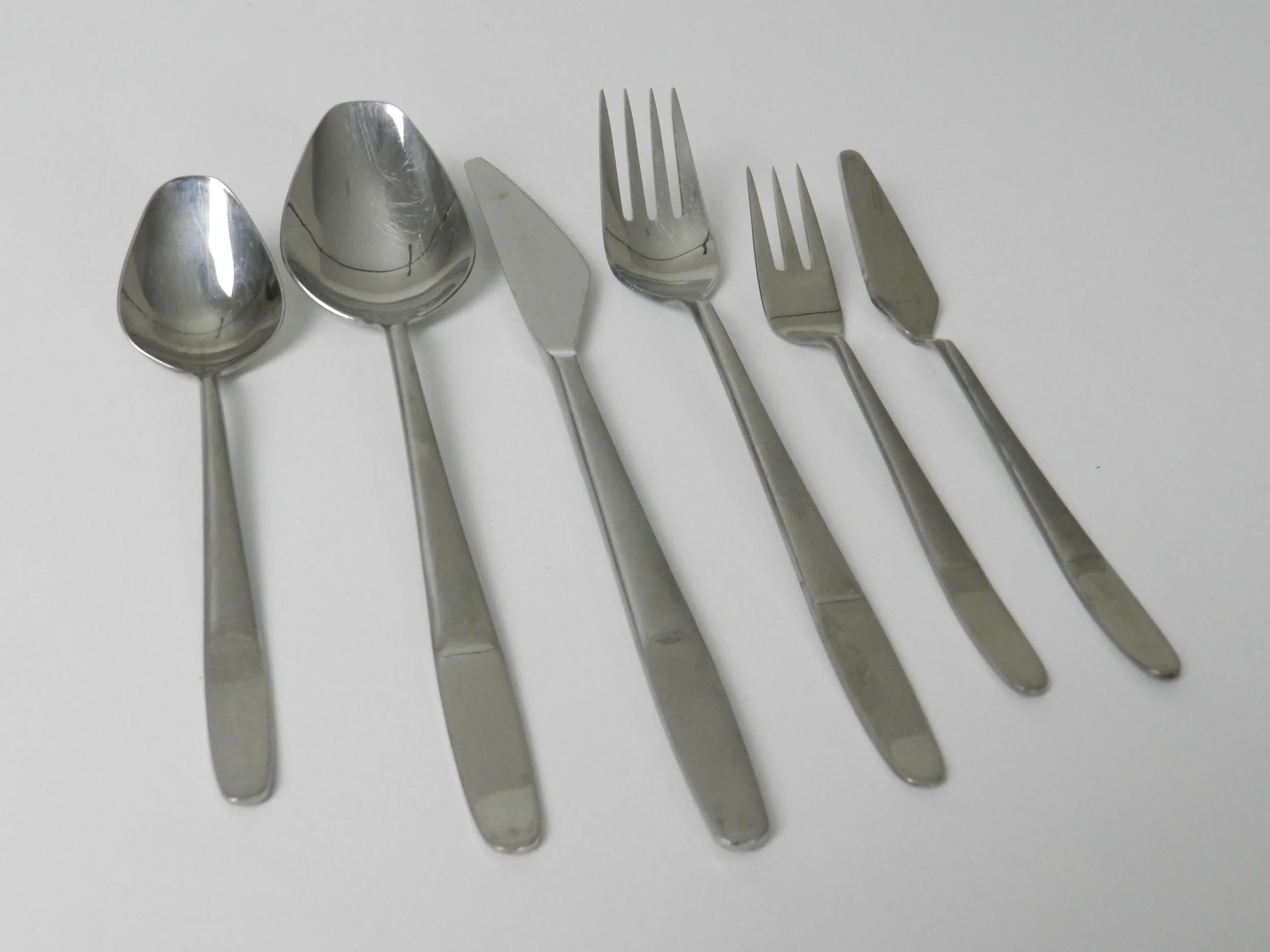 Modernist stainless steel flatware set (model 2070) designed by Helmut Alder for Amboss. Six piece place settings for 10 plus 10 extra pieces, total of 70.  Austria, 1960s.