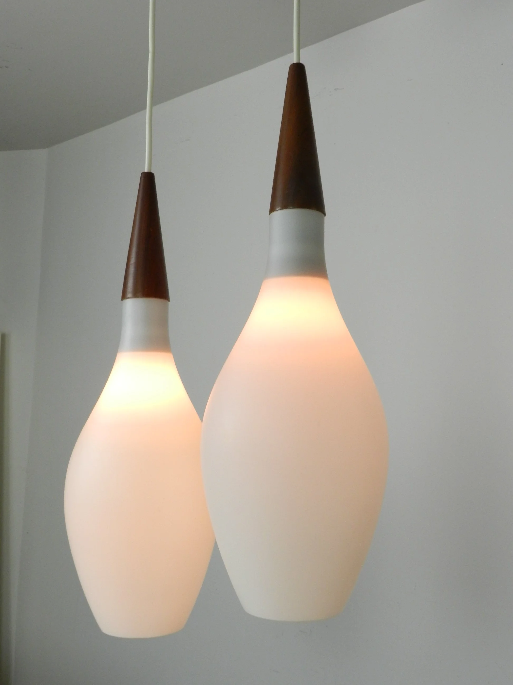 Pair of opaline glass pendant lamps with teak finials.  Scandianvia, 1960s.
