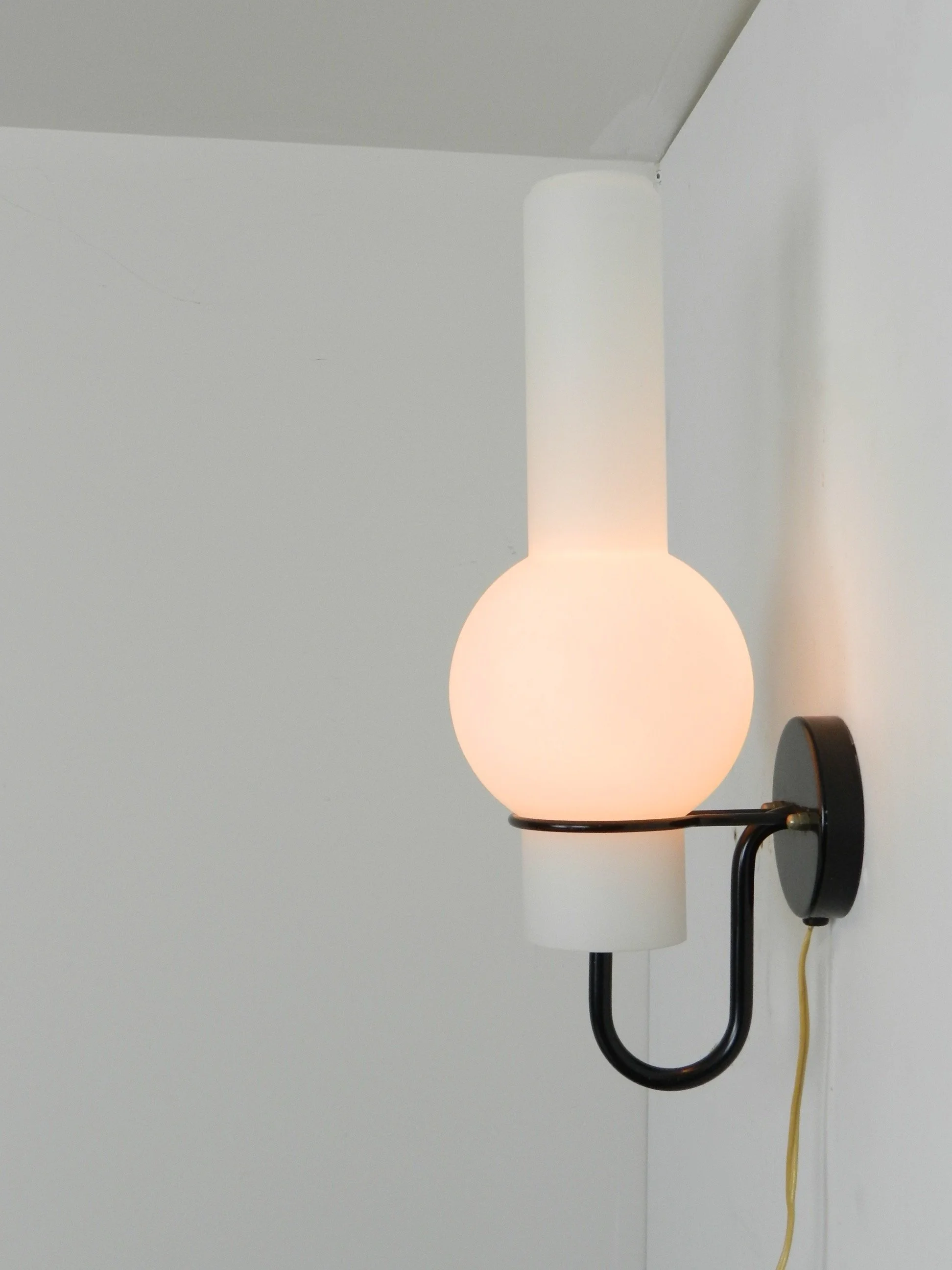 “Quinquet” wall lamp by Raak. Opaline glass and metal fixture.  Netherlands, 1960s.