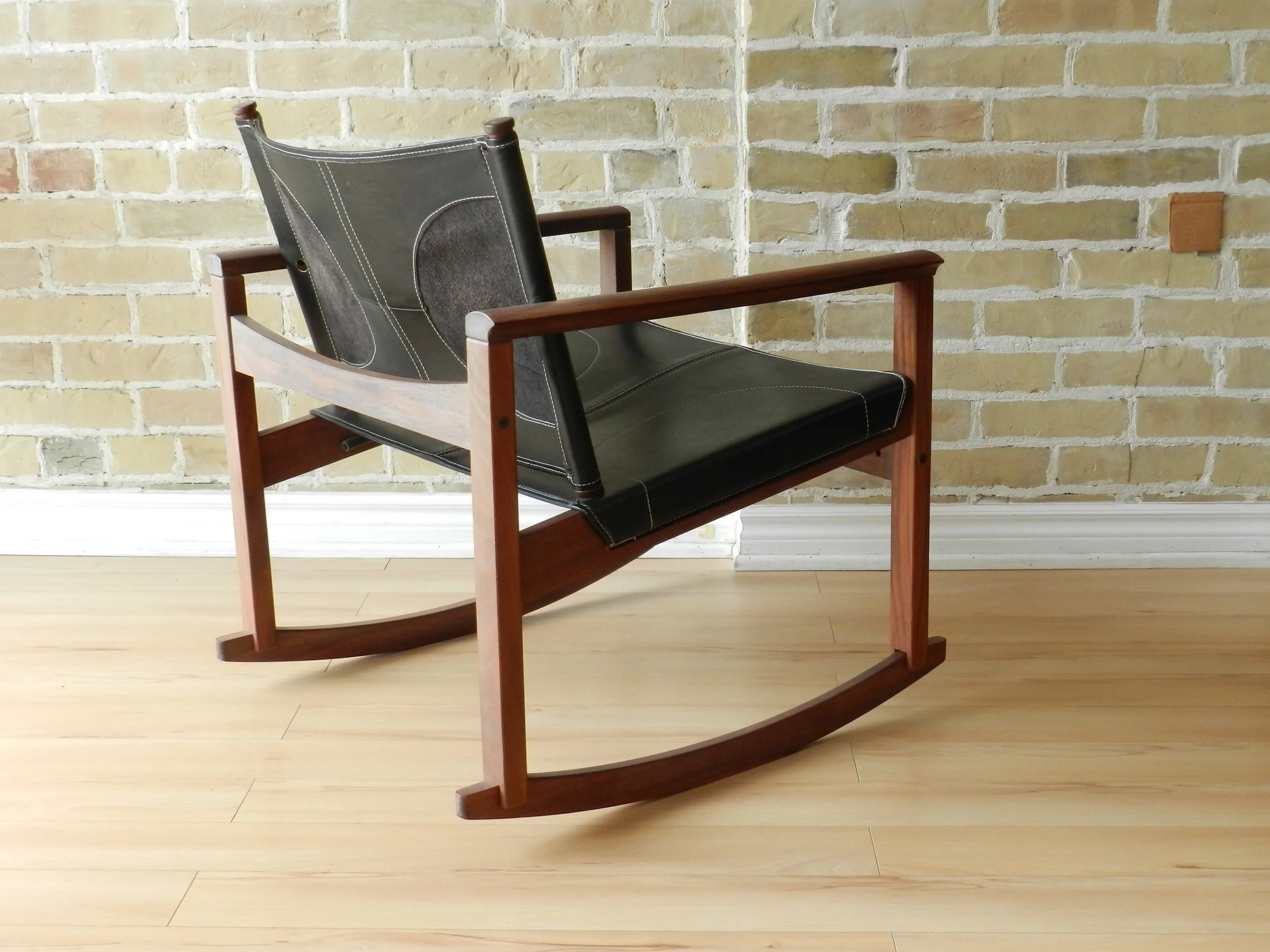 Peglev rocking chair designed by Michel Amoult for Mobilia Cotemporanea. Rosewood with leather upholstery.  Brazil, 1960s.