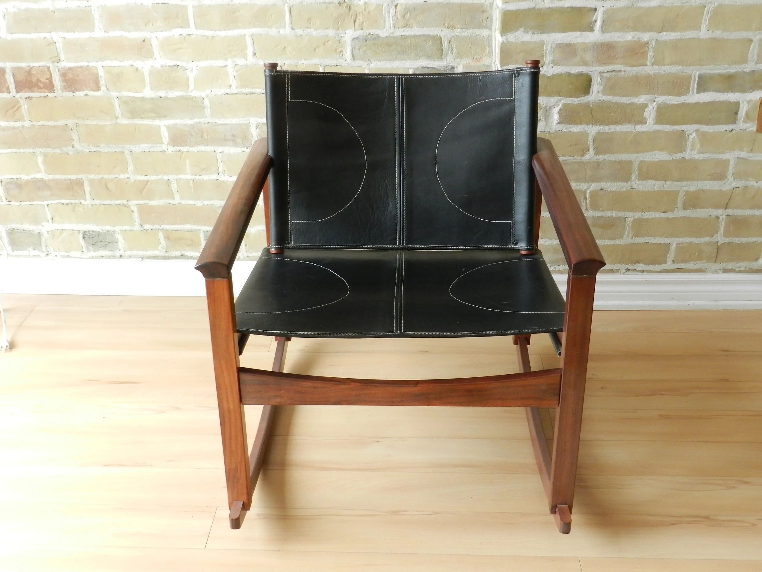 Peglev rocking chair designed by Michel Amoult for Mobilia Cotemporanea. Rosewood with leather upholstery.  Brazil, 1960s.