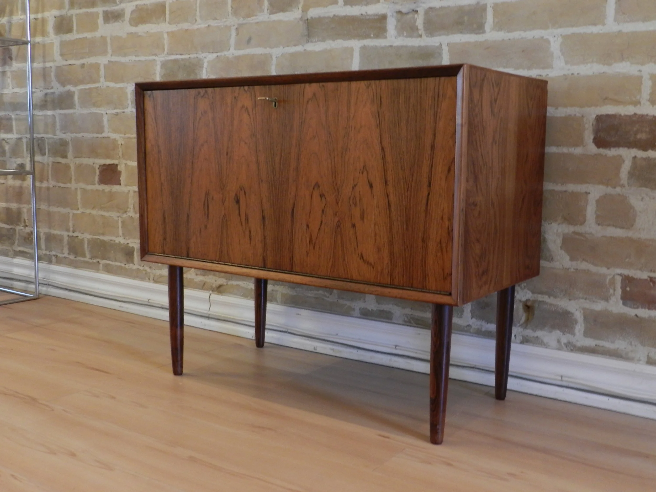 Compact rosewood drop door cabinet designed by Poul Cadovius.  Denmark, 1960s.