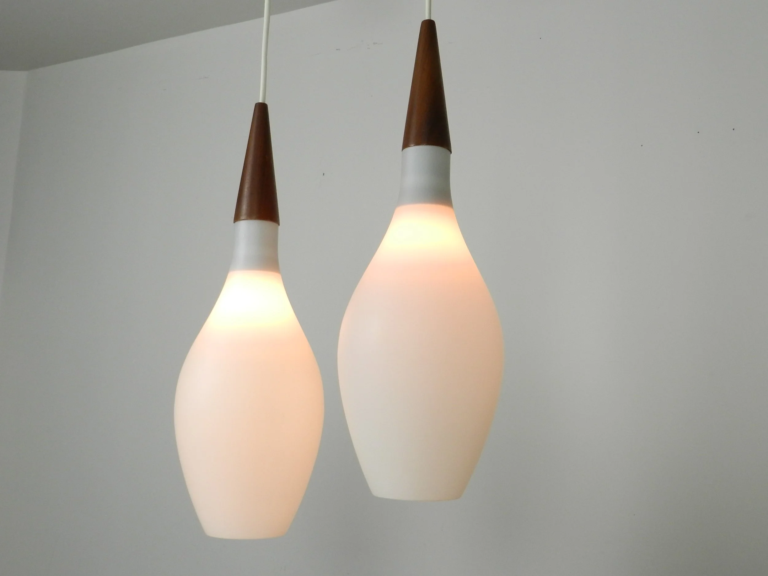 Pair of opaline glass pendant lamps with teak finials.  Scandianvia, 1960s.