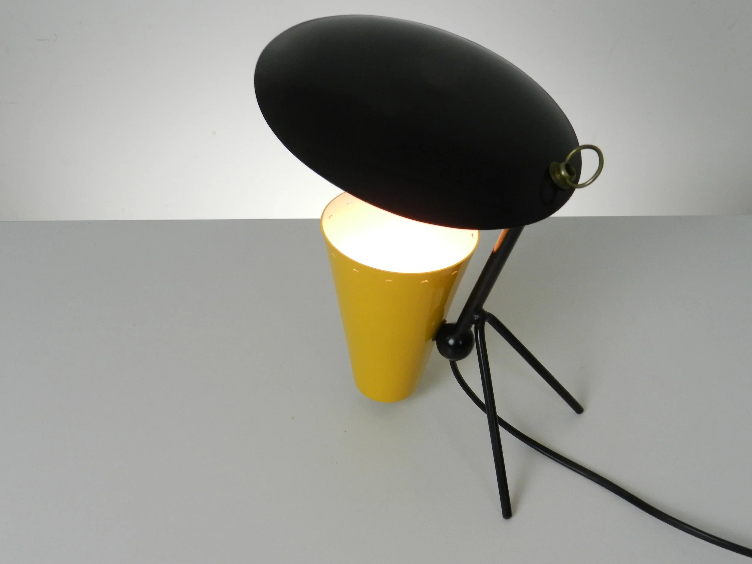 Compact mid century modern reflector lamp in enameled metal. Probably originates from Italy or France. Can be used as a table or wall lamp.  Circa 1950s.