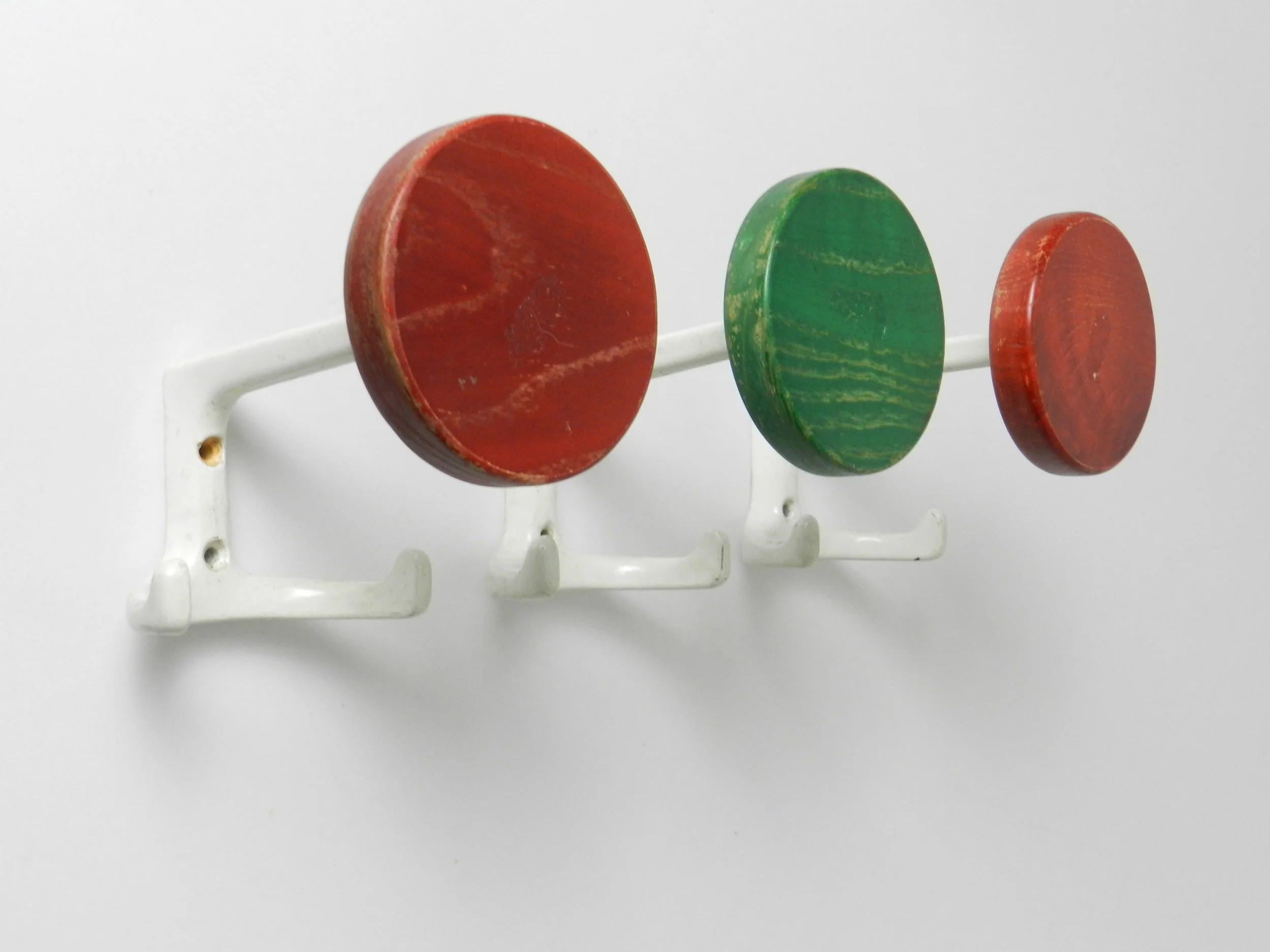 Set of three mid century coat hooks in enameled metal and wood.  Germany, 1970s.