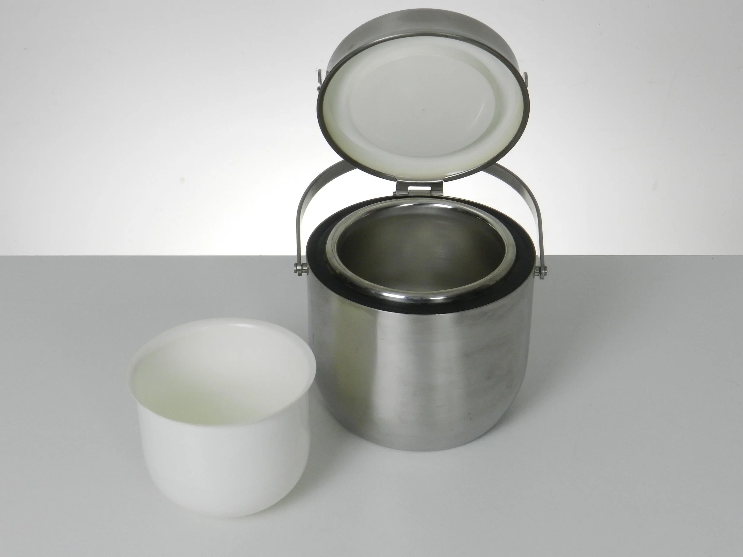 Stainless steel ice bucket with mechanical lid, glass interior and plastic liner. Designed by Anselmo Vitale and Carlo Mazzeri for Alessi.  Italy, 1970s.