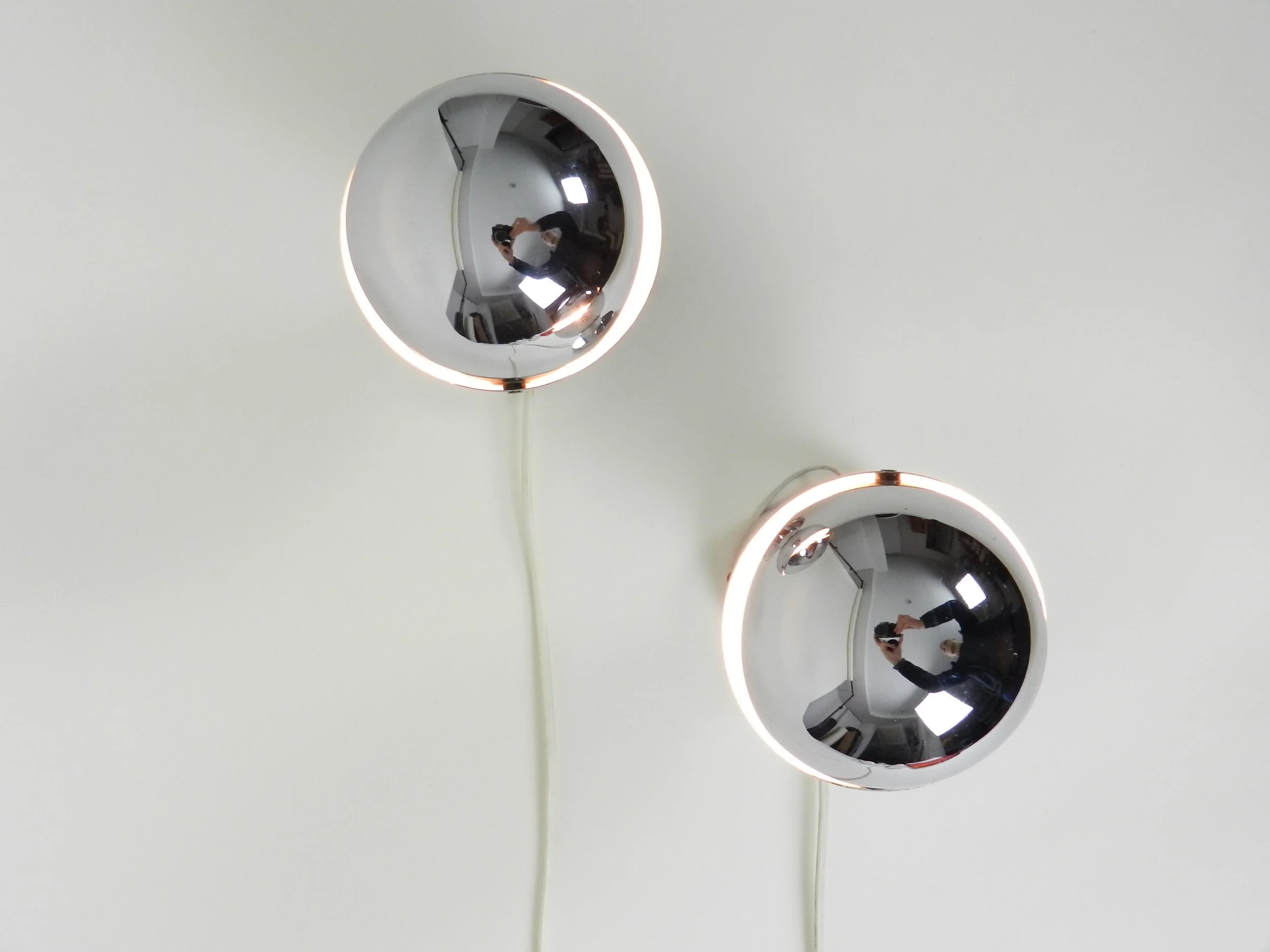 Pair of space age chrome eclipse wall lamps.  Netherlands, 1970s.