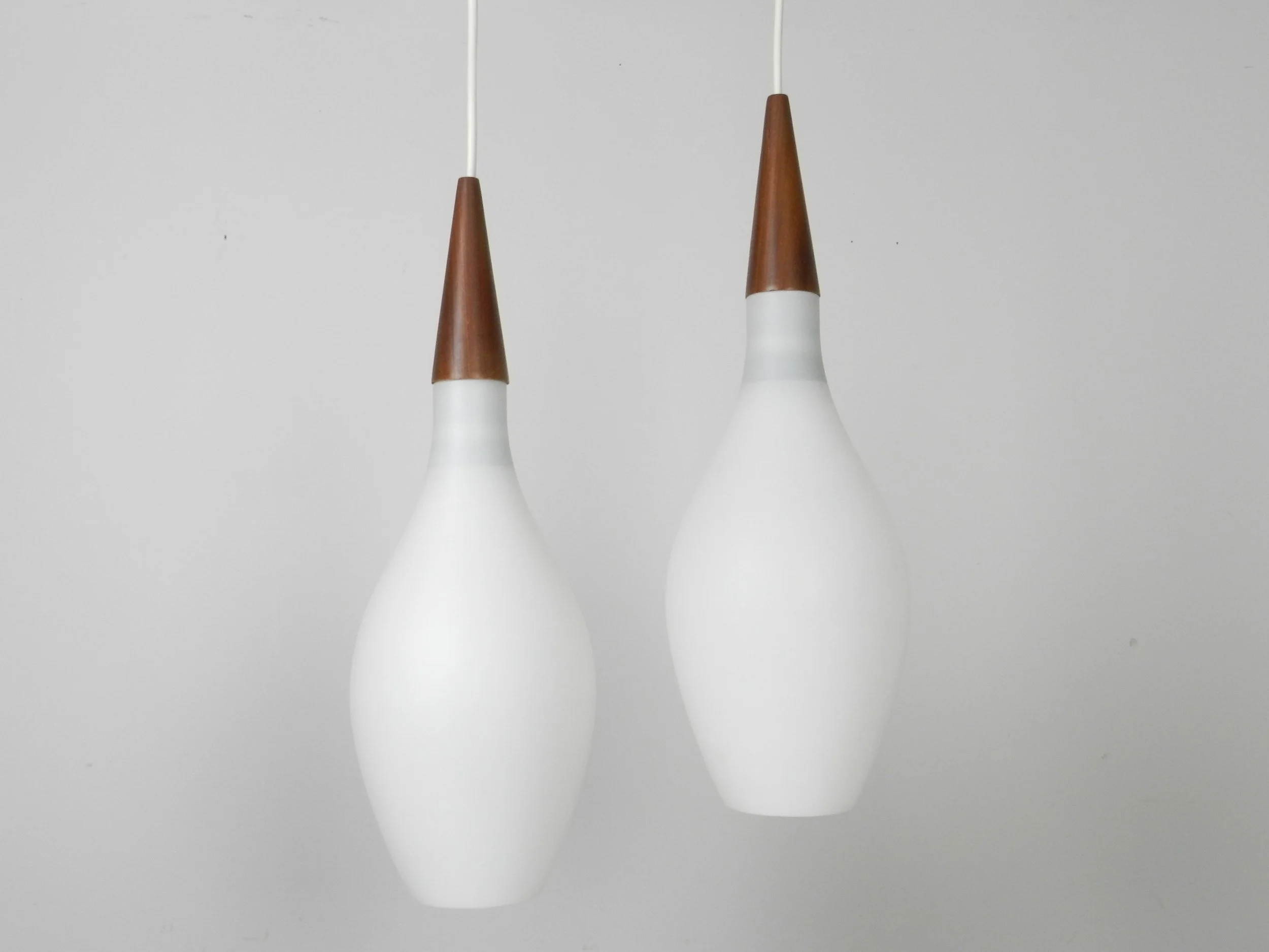 Pair of opaline glass pendant lamps with teak finials.  Scandianvia, 1960s.