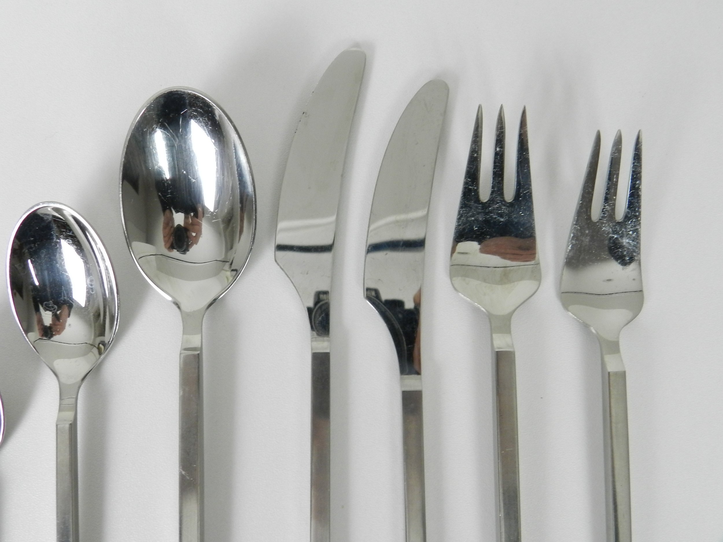 Stainless steel “Rondo” flatware set designed by Per Willemoes for Lundtofte. 8 - seven piece place settings (missing one tea spoon) plus 6 serving pieces, total of 61 pieces.  Denmark, 1970s.