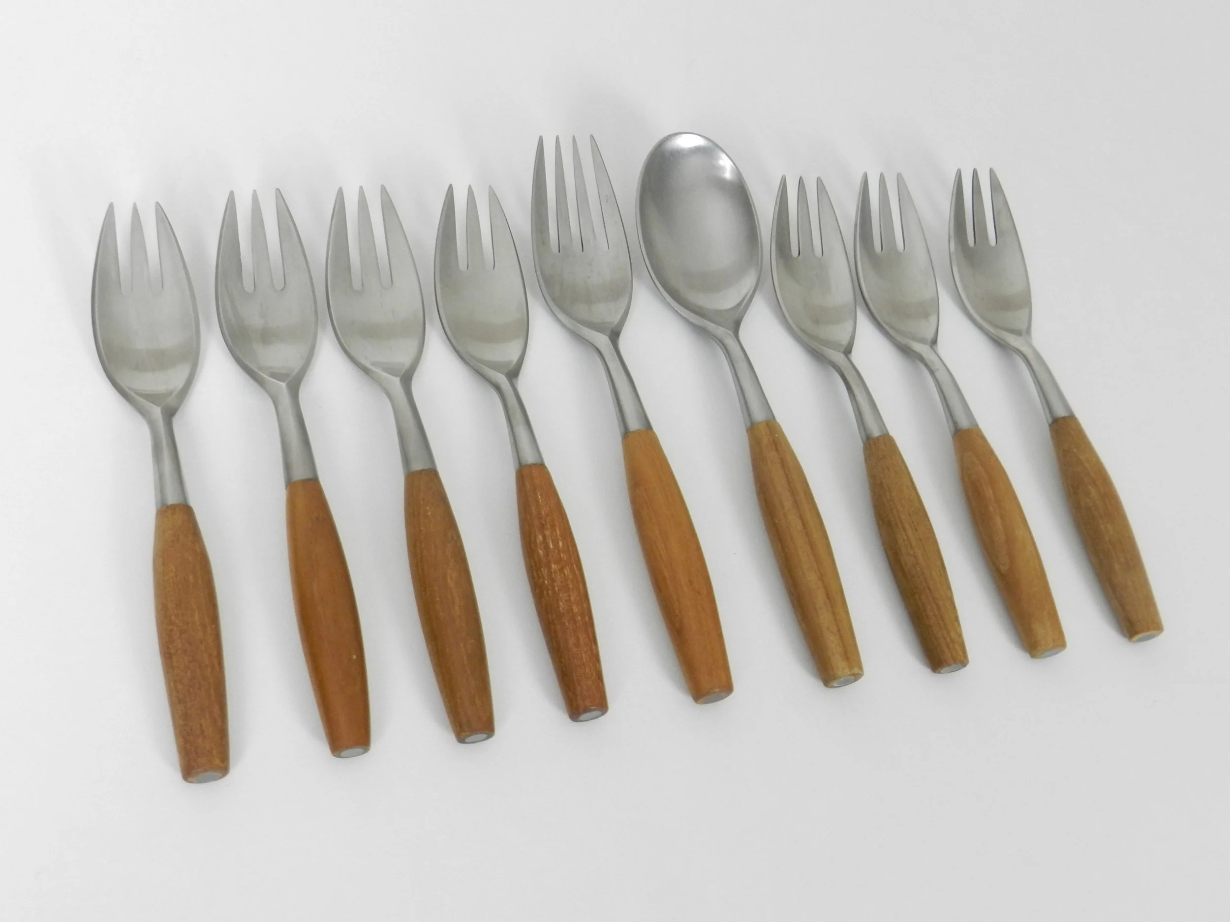 Stainless steel and teak Fjord flatware deigned by Jens Quistgaard for Dansk. Set includes 7 salad/desert forks, 1 dinner fork amd 1 soup spoon.  Germany, 1960s.
