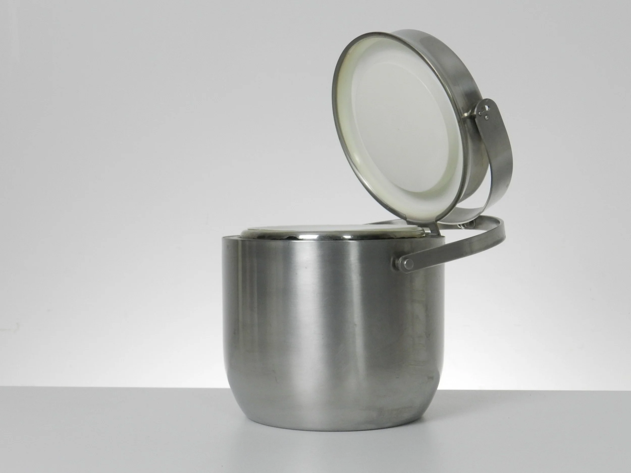 Stainless steel ice bucket with mechanical lid, glass interior and plastic liner. Designed by Anselmo Vitale and Carlo Mazzeri for Alessi.  Italy, 1970s.