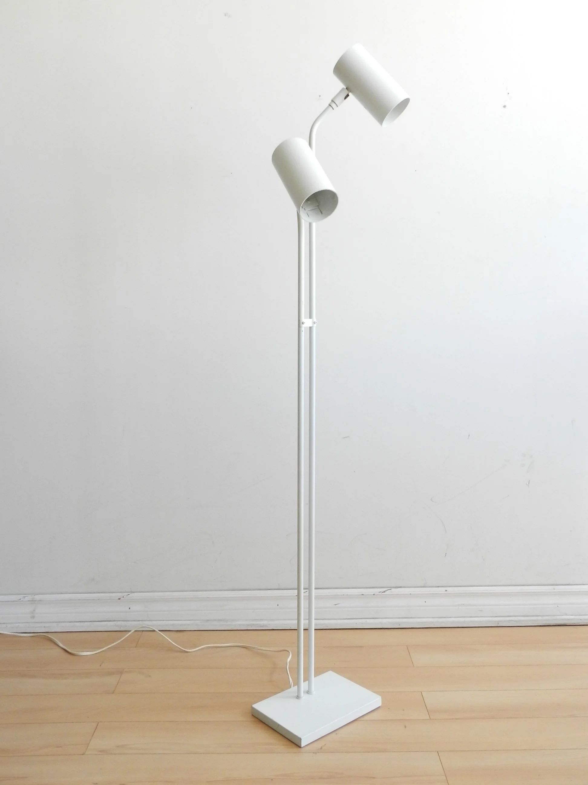 Modernist floor lamp in white enameled metal.  circa 1980s.