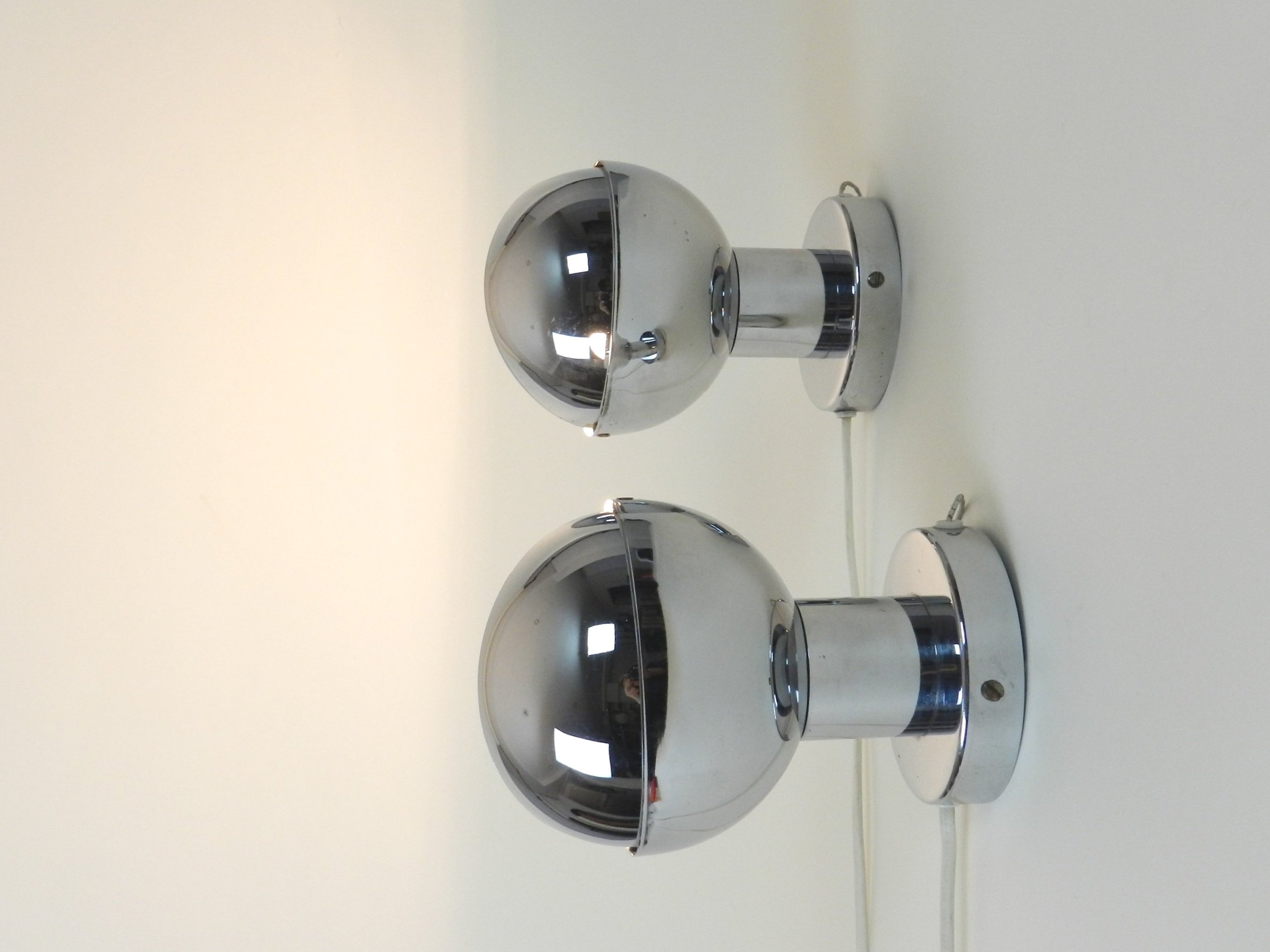 Pair of space age chrome eclipse wall lamps. Netherlands, 1970s.