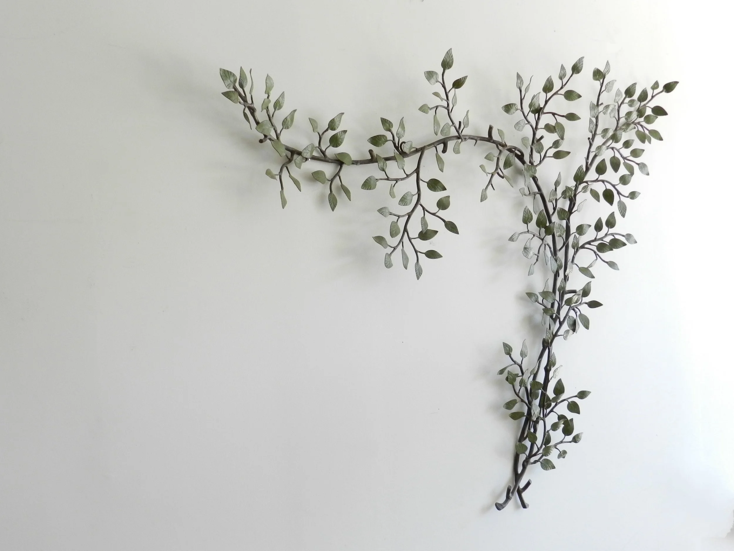 Vintage high quality wall sculpture of branch with leaves in painted metal.  circa 1940s.