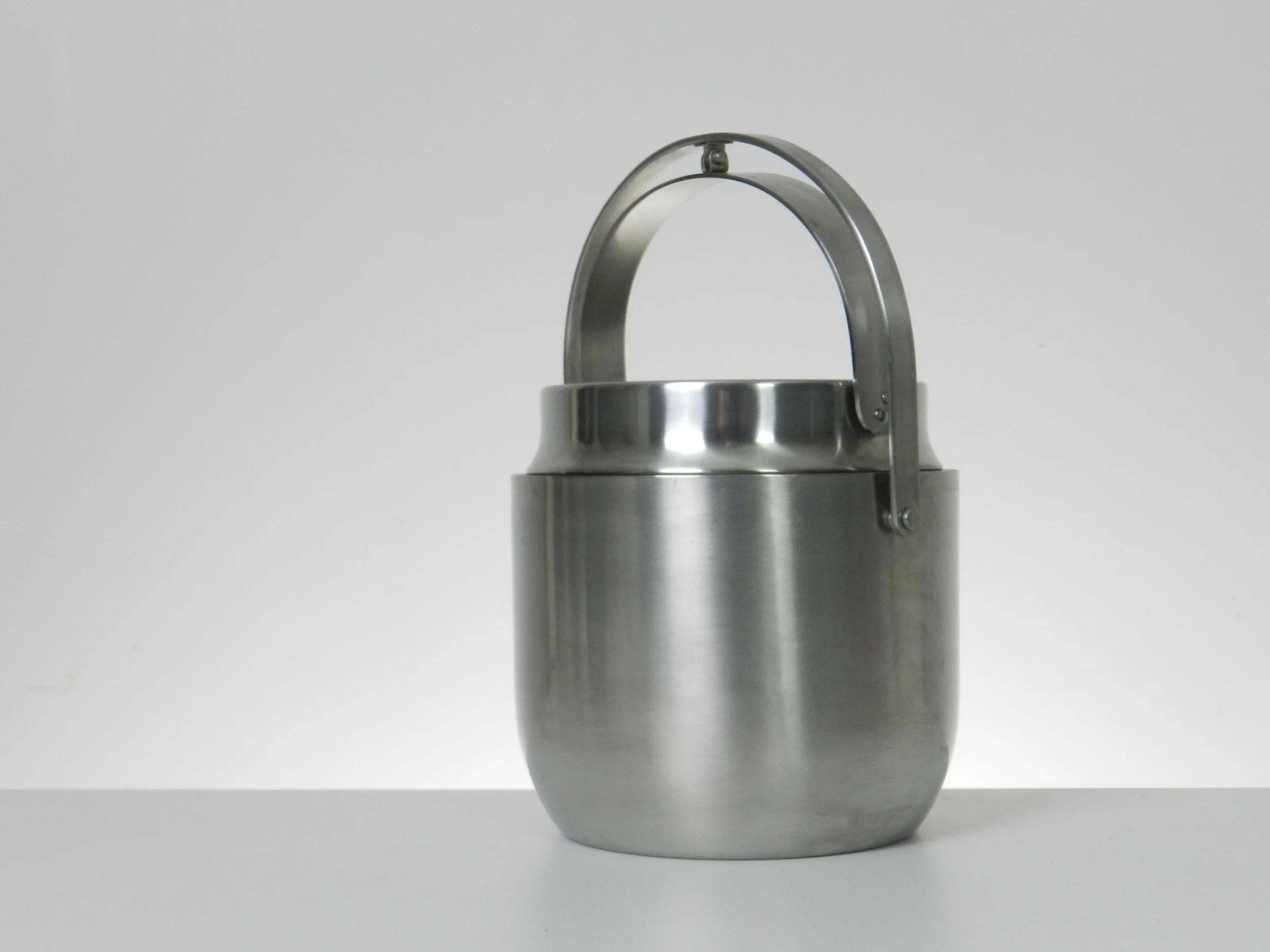Stainless steel ice bucket with mechanical lid, glass interior and plastic liner. Designed by Anselmo Vitale and Carlo Mazzeri for Alessi.  Italy, 1970s.