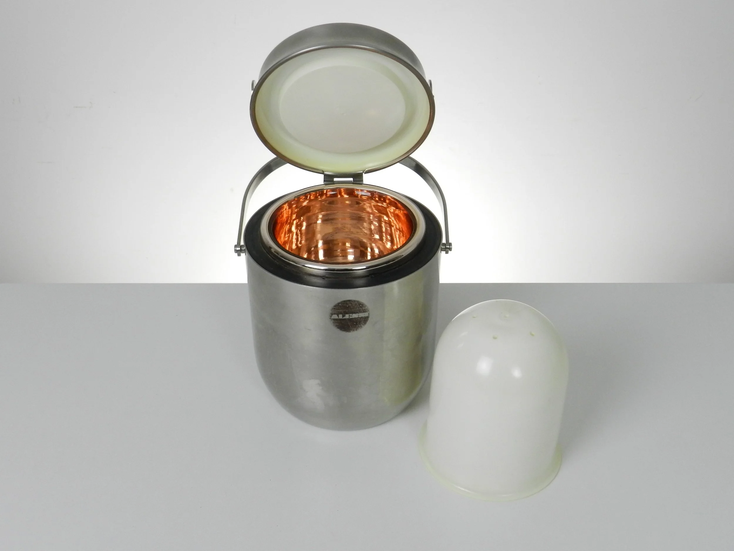 Stainless steel ice bucket with its mechanical lid, glass interior and plastic liner. Designed by Anselmo Vitale and Carlo Mazzeri for Alessi.  Italy, 1970s.