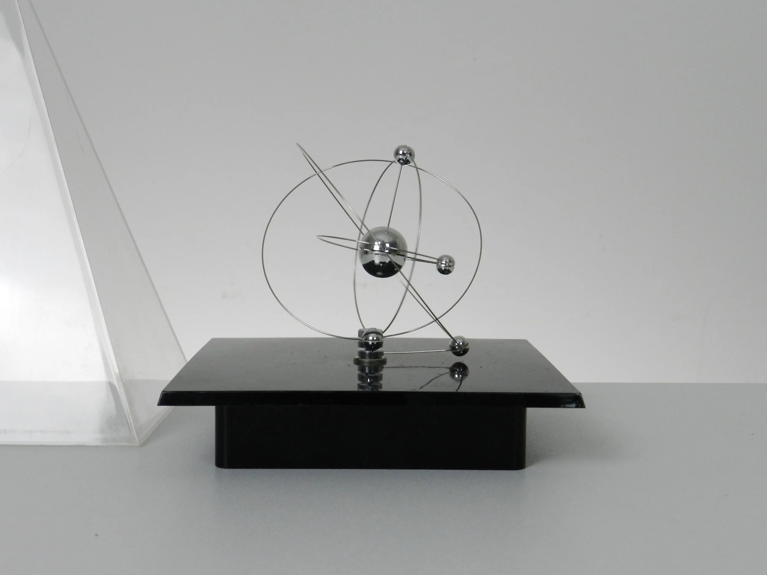 Space age planetary orbit clock in clear and black acrylic with chrome wires.  circa 1980s.