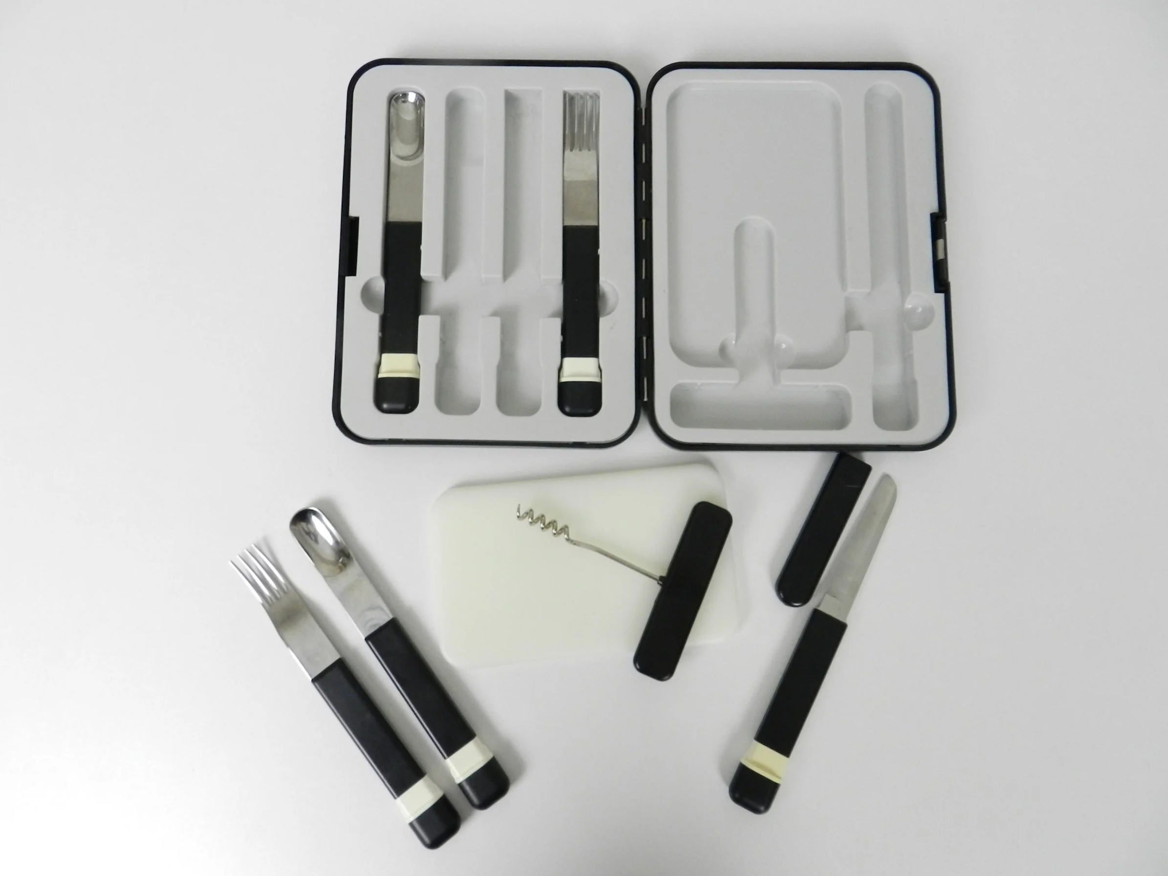 Post modern picnic set contains 2 spoons, 2 forks, cork screw, sharp knife in protective case, cutting board & heavy duty plastic travel case. Japan, 1980s.