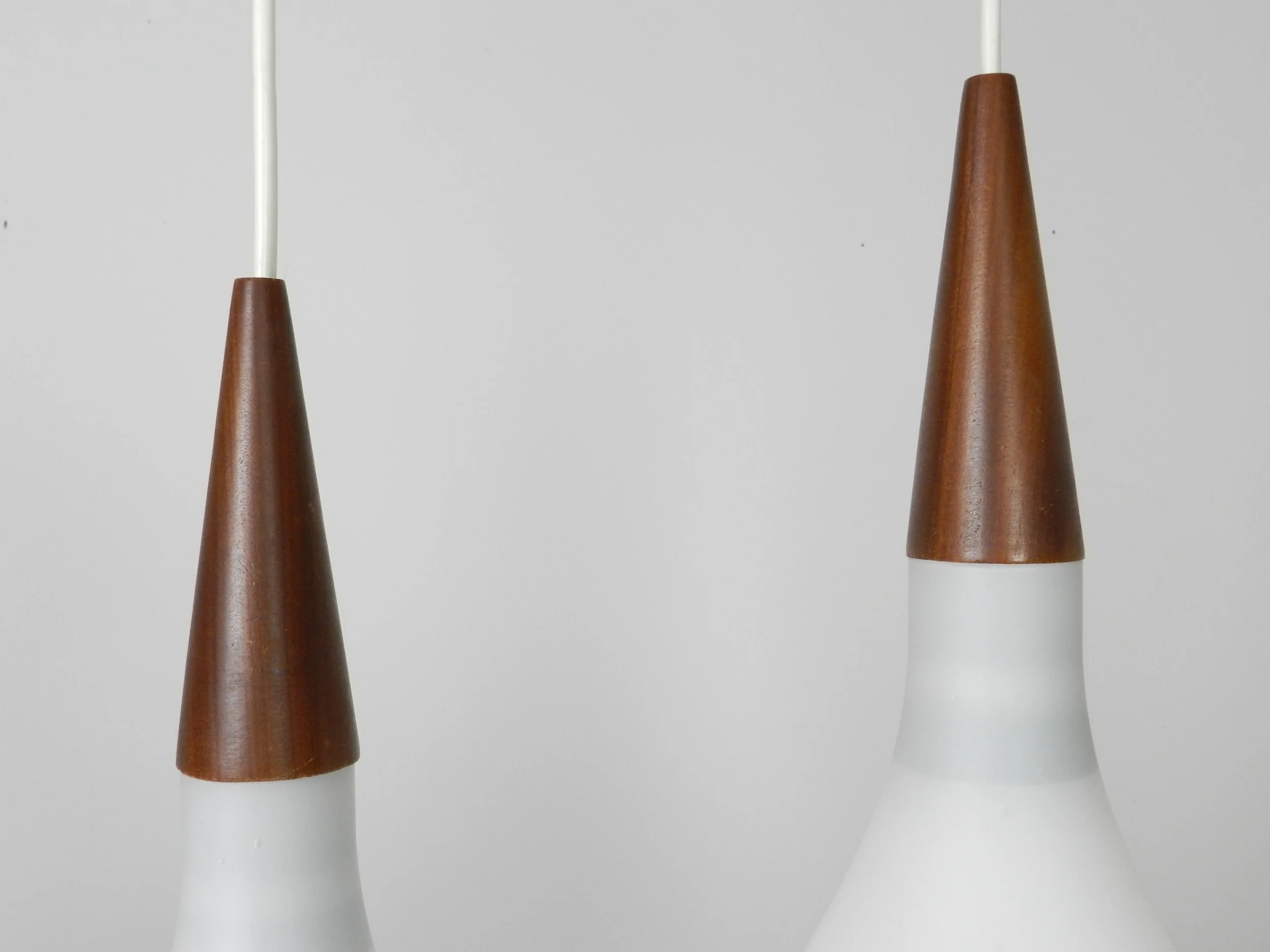 Pair of opaline glass pendant lamps with teak finials.  Scandianvia, 1960s.