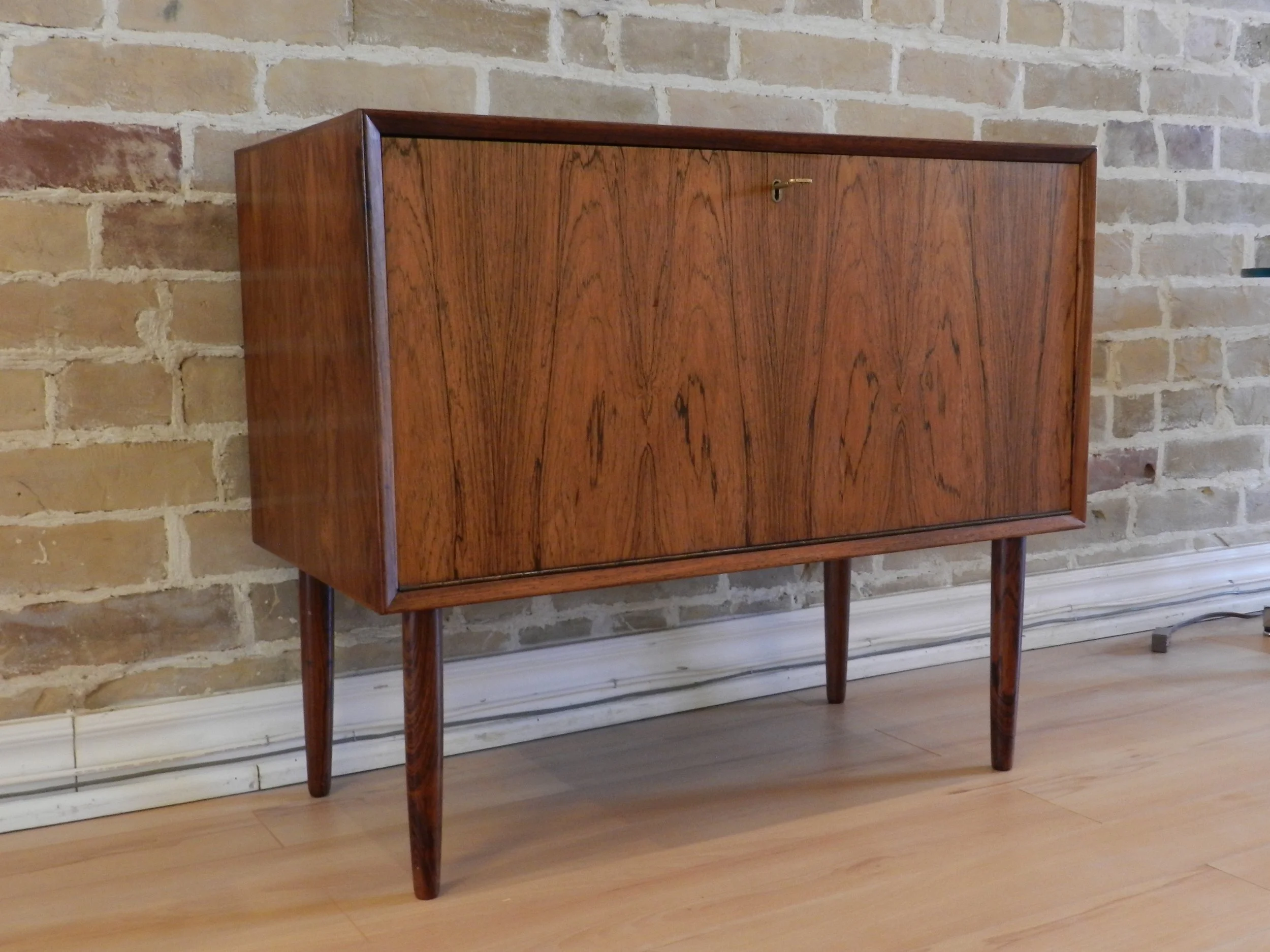 Compact rosewood drop door cabinet designed by Poul Cadovius.  Denmark, 1960s.