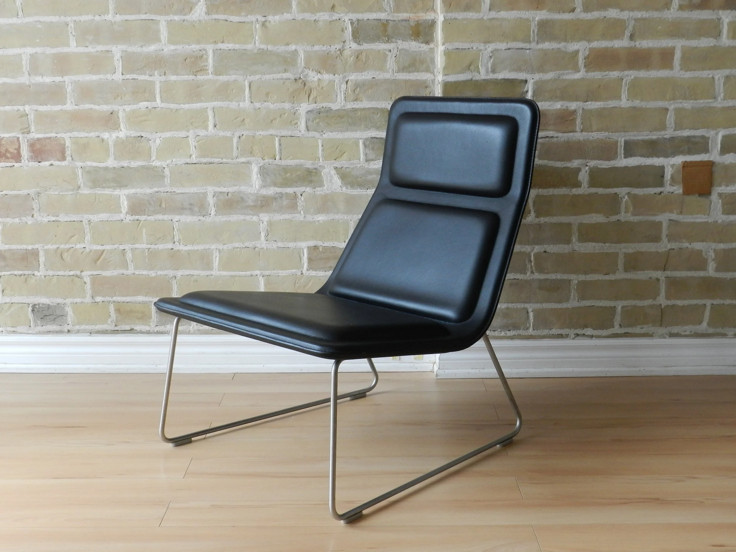 Pair of Low Pad lounge chairs designed by Jasper Morrison for Cappellini. Black leather upholstery on steel bases.  Italy, 1999.