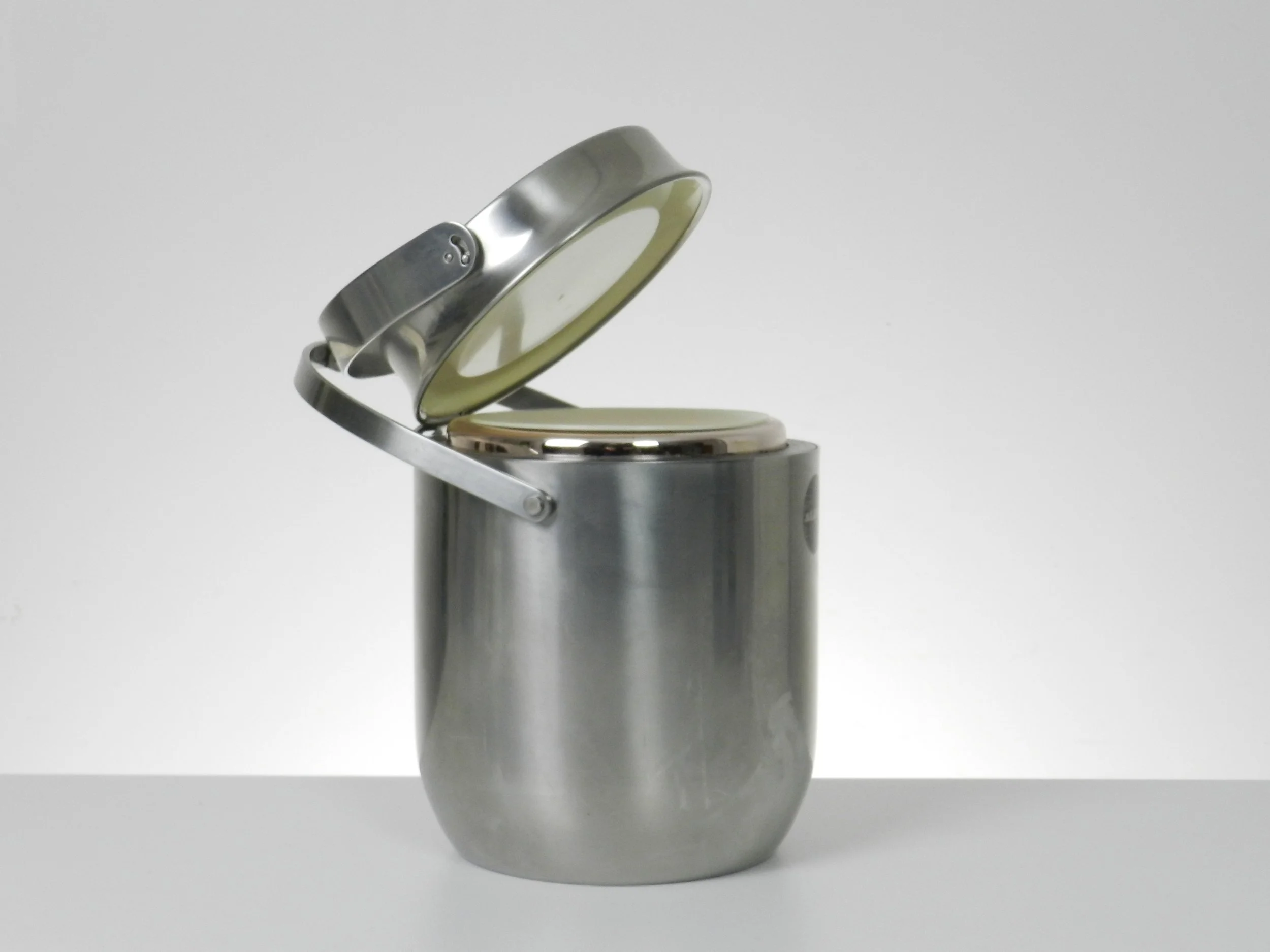 Stainless steel ice bucket with its mechanical lid, glass interior and plastic liner. Designed by Anselmo Vitale and Carlo Mazzeri for Alessi.  Italy, 1970s.
