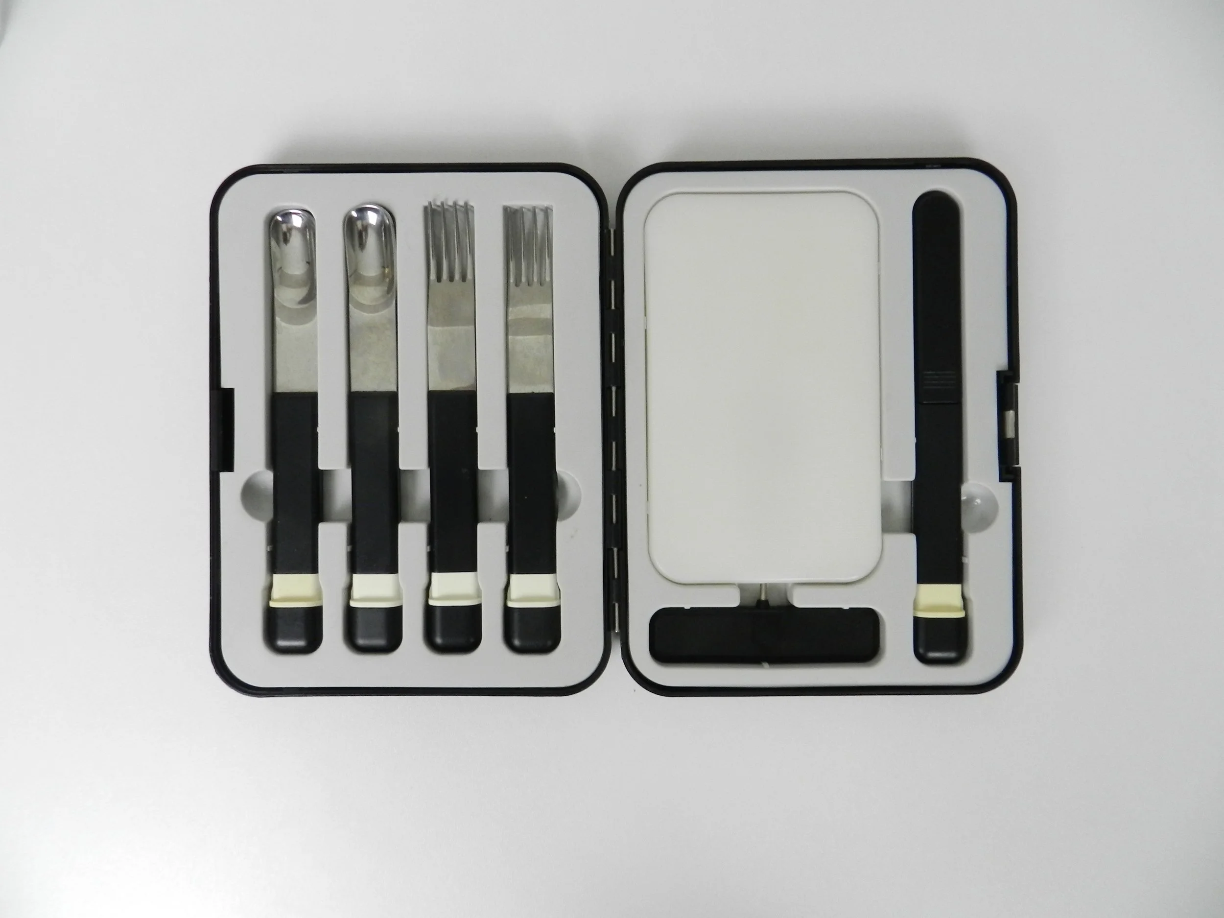 Post modern picnic set contains 2 spoons, 2 forks, cork screw, sharp knife in protective case, cutting board & heavy duty plastic travel case.  Japan, 1980s.