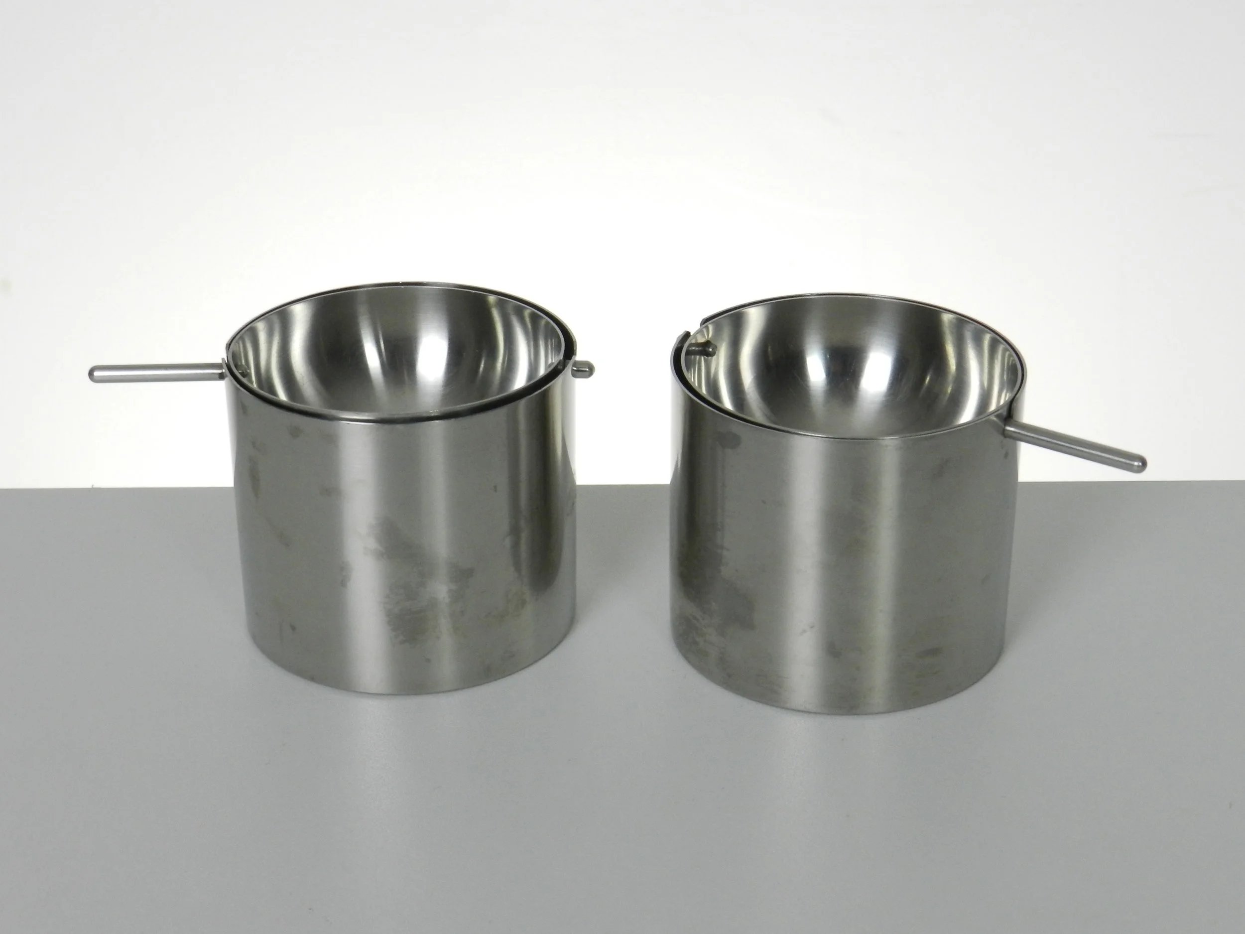 Pair of Cylinda Line stainless steel revolving ashtrays designed by Arne Jacobsen for Stelton.  Denmark, 1960s.