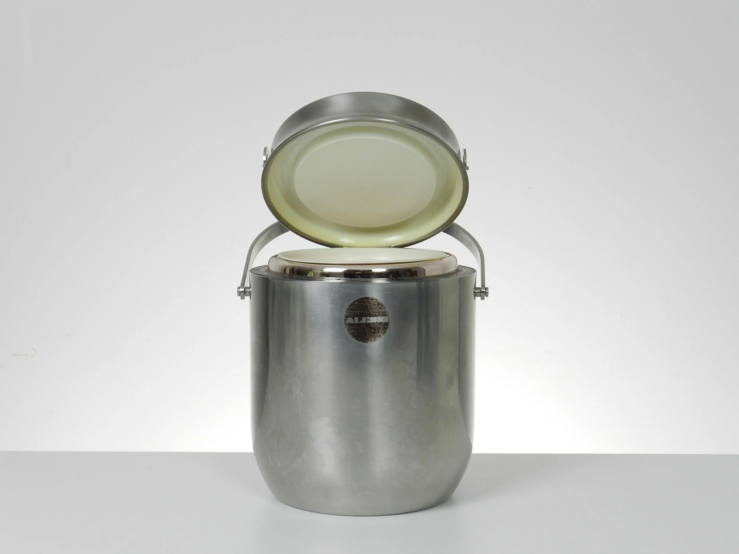 Stainless steel ice bucket with its mechanical lid, glass interior and plastic liner. Designed by Anselmo Vitale and Carlo Mazzeri for Alessi.  Italy, 1970s.