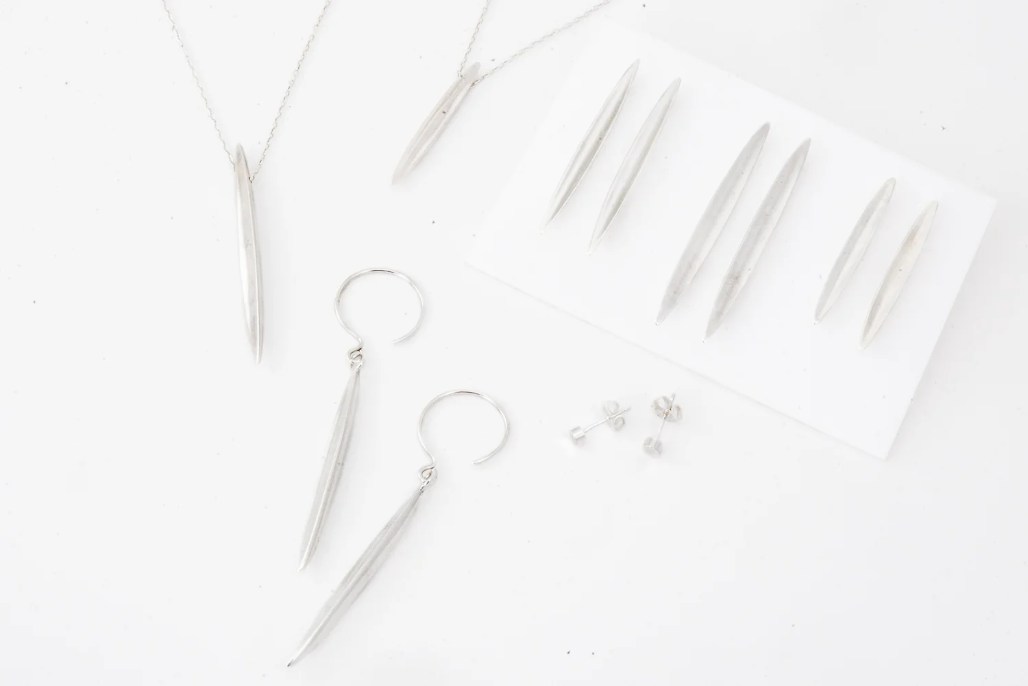 Long seed pendants on chains in two sizes, dangle earrings, and bar earrings (three sizes), plus concave round post earrings, all in sterling silver