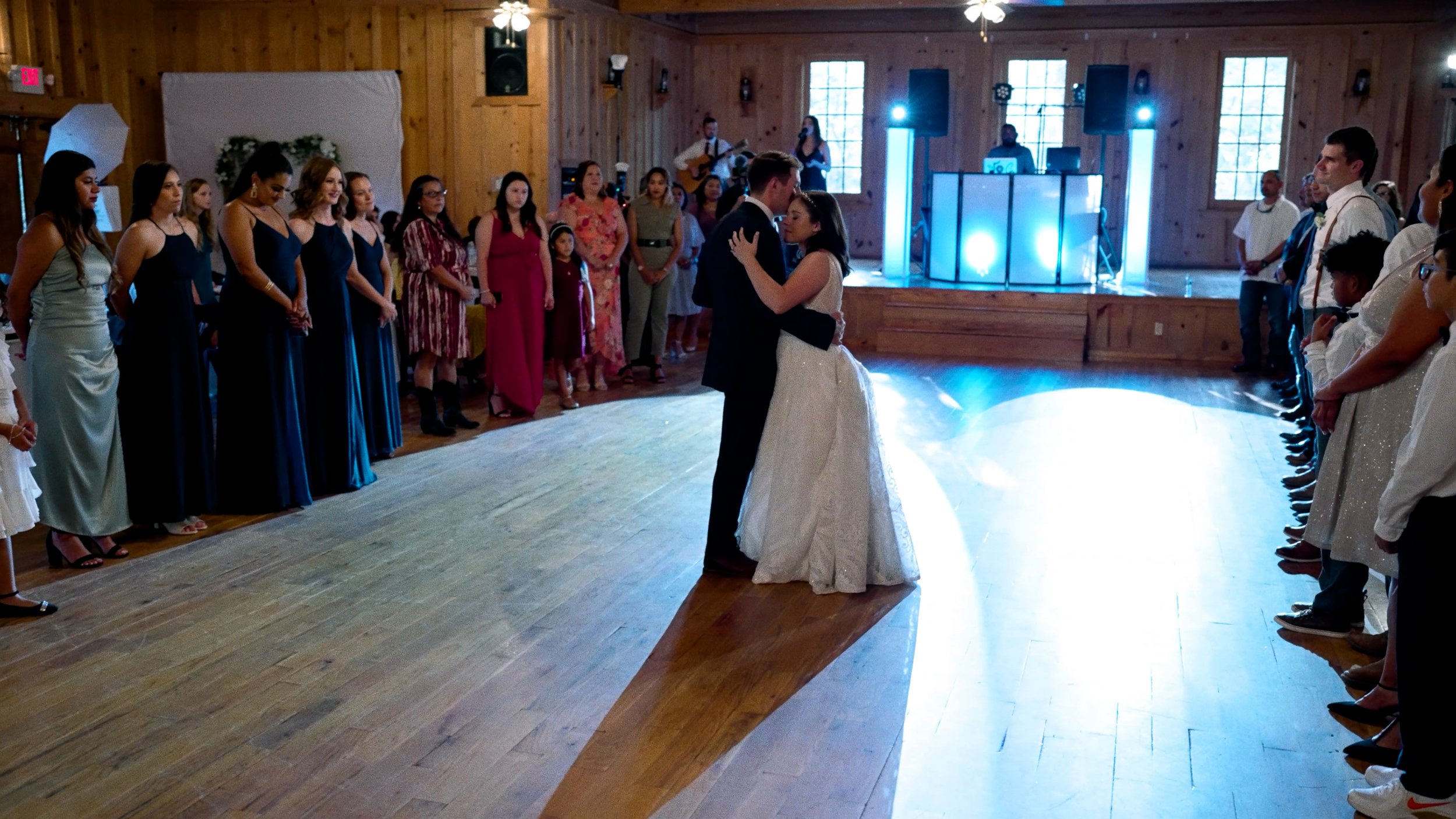 bride and groom first dance embrace DJ lights dance floor