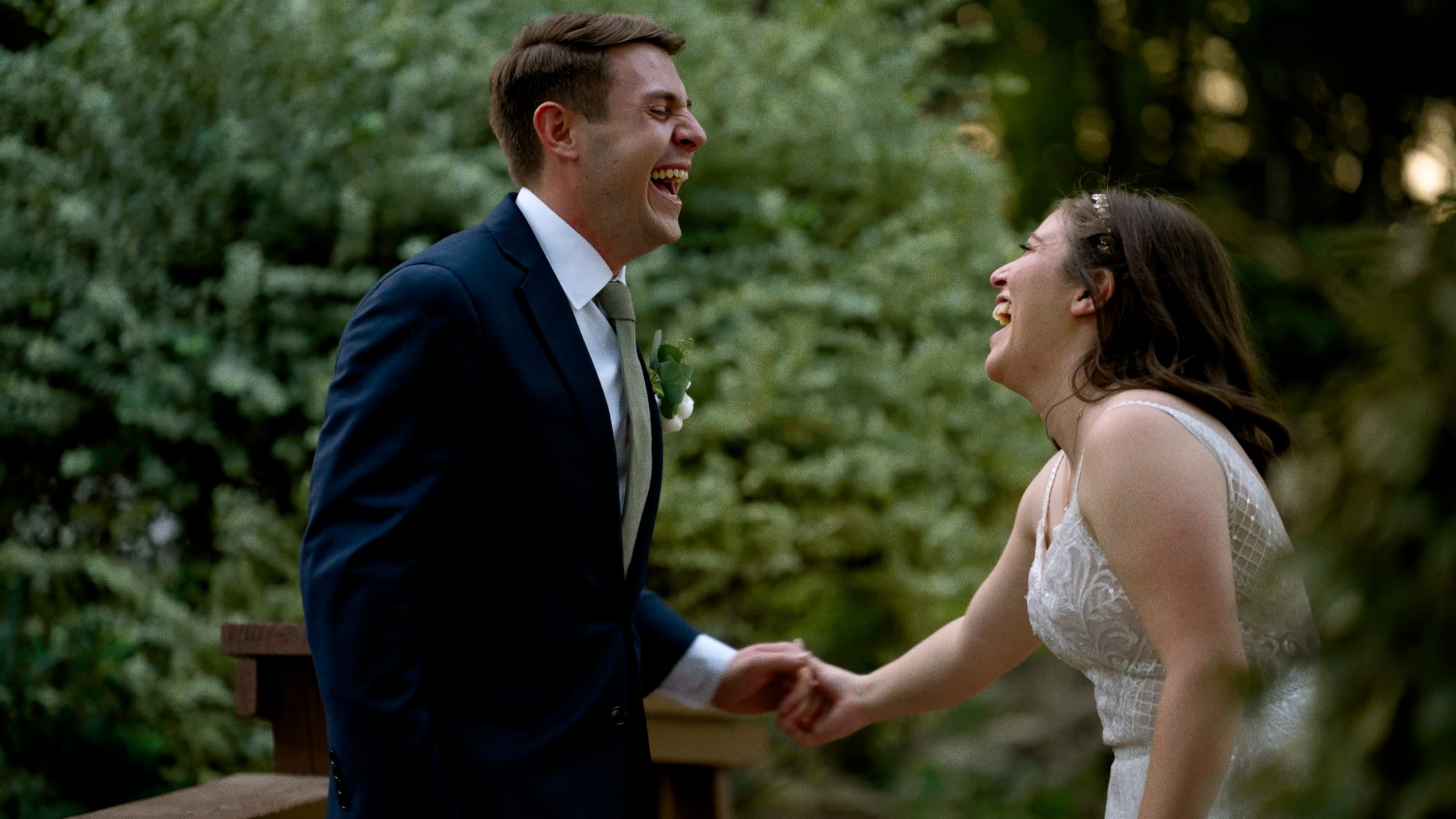 bride and groom laughing dancing on bridge sunset outside