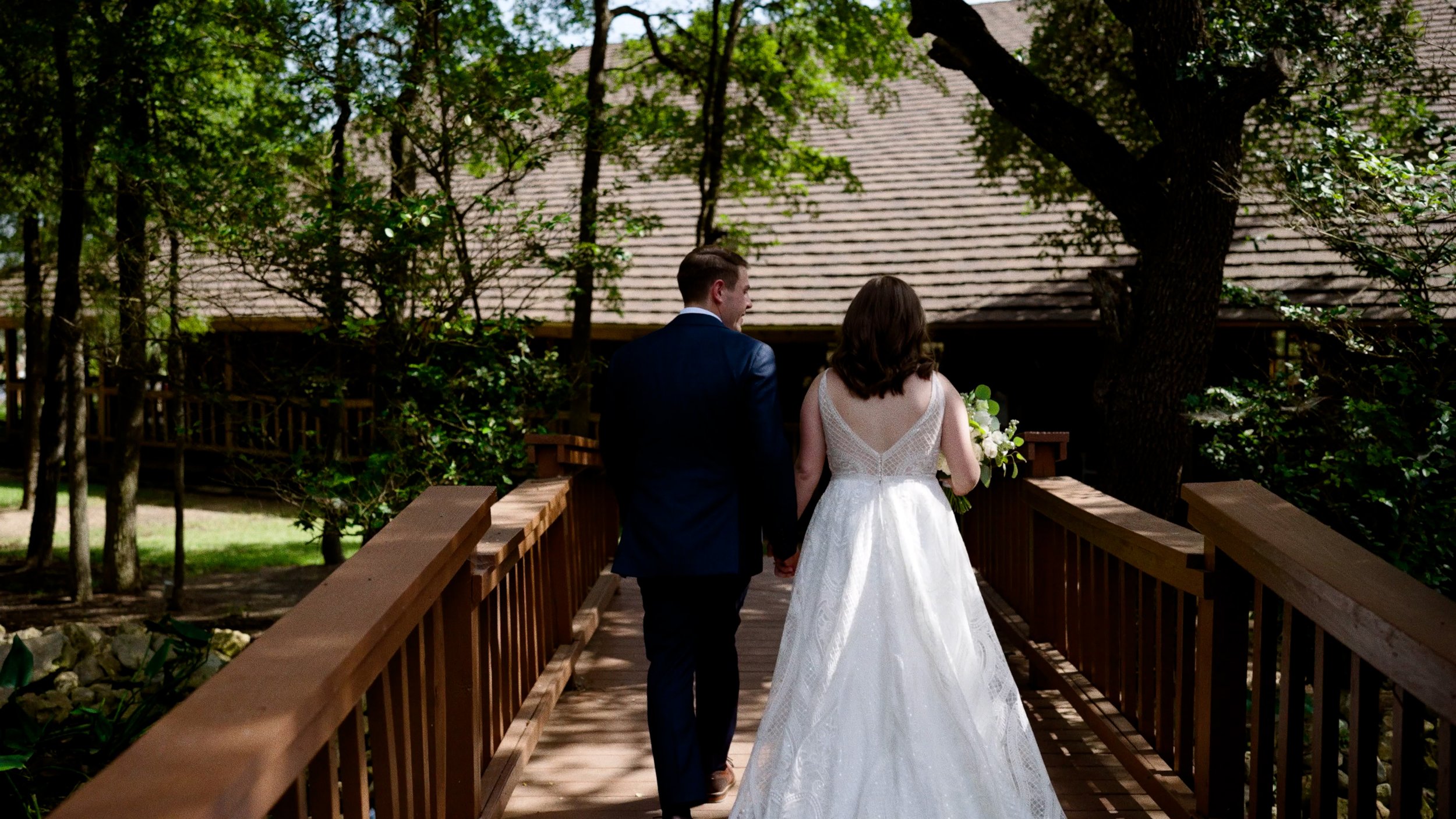 bride and groom walk across bridge after wedding ceremony.jpg