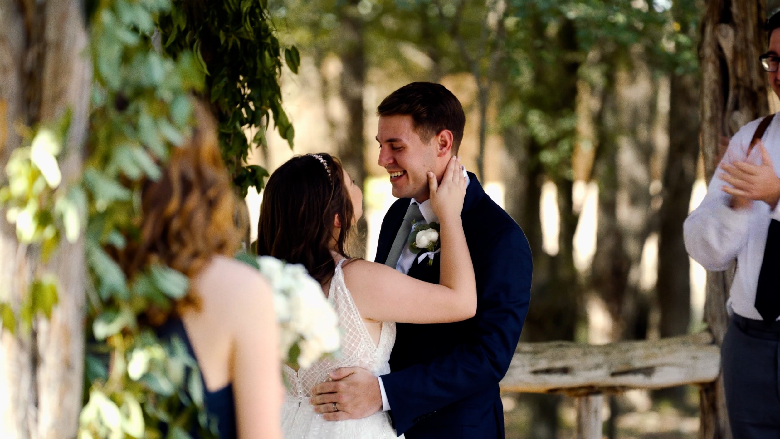 bride holds groom face smile after first kiss during wedding ceremony