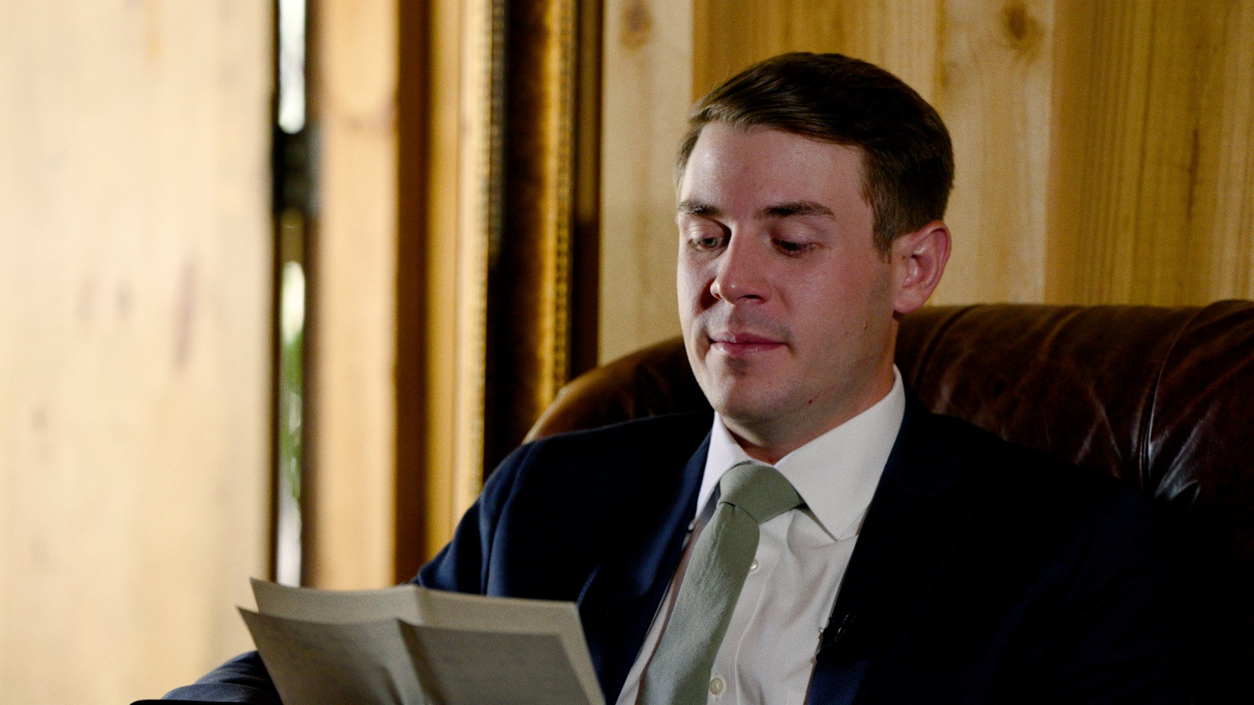 groom reading letter sitting on couch