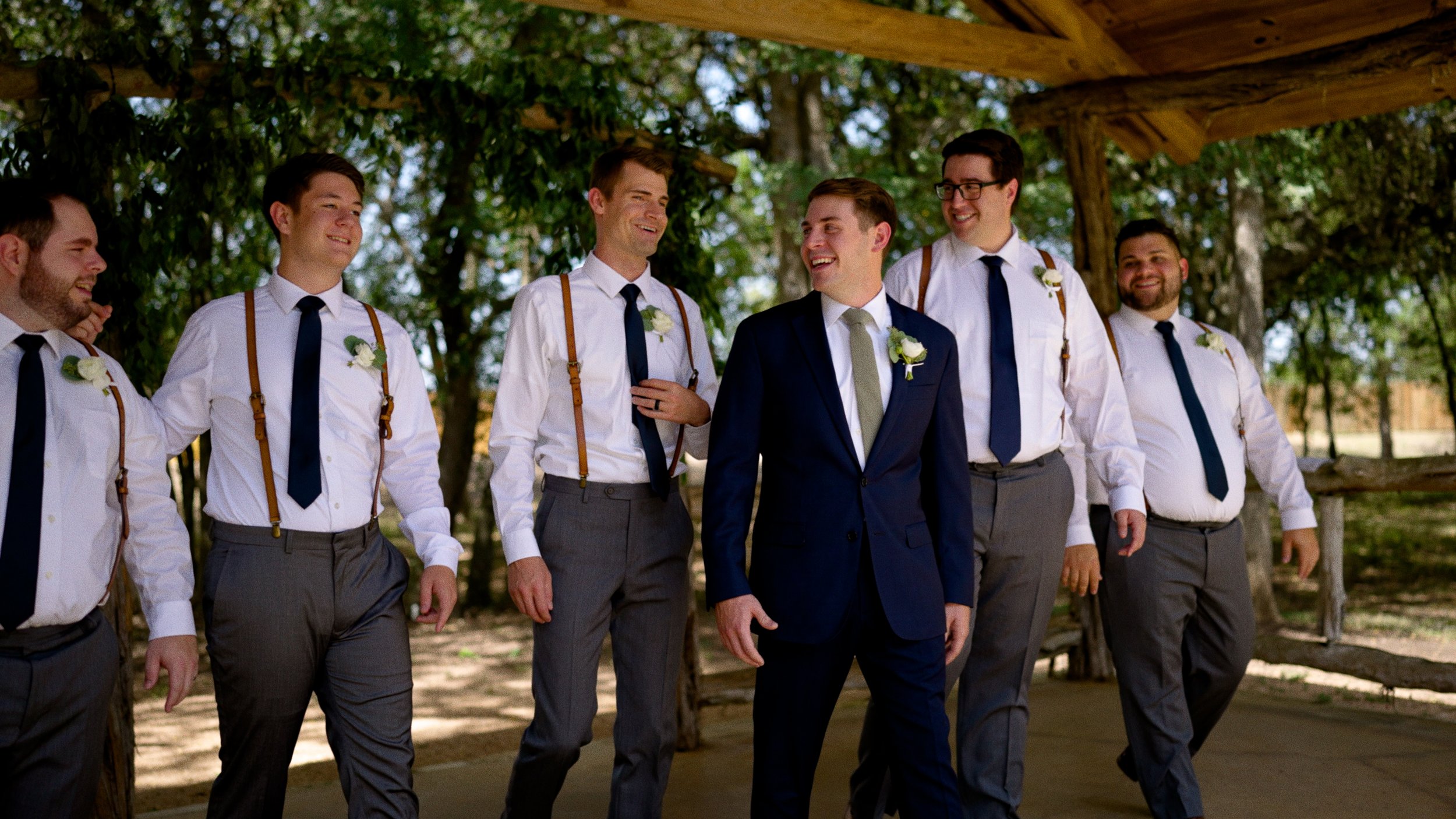 groom walking and laughing with groosmen outside