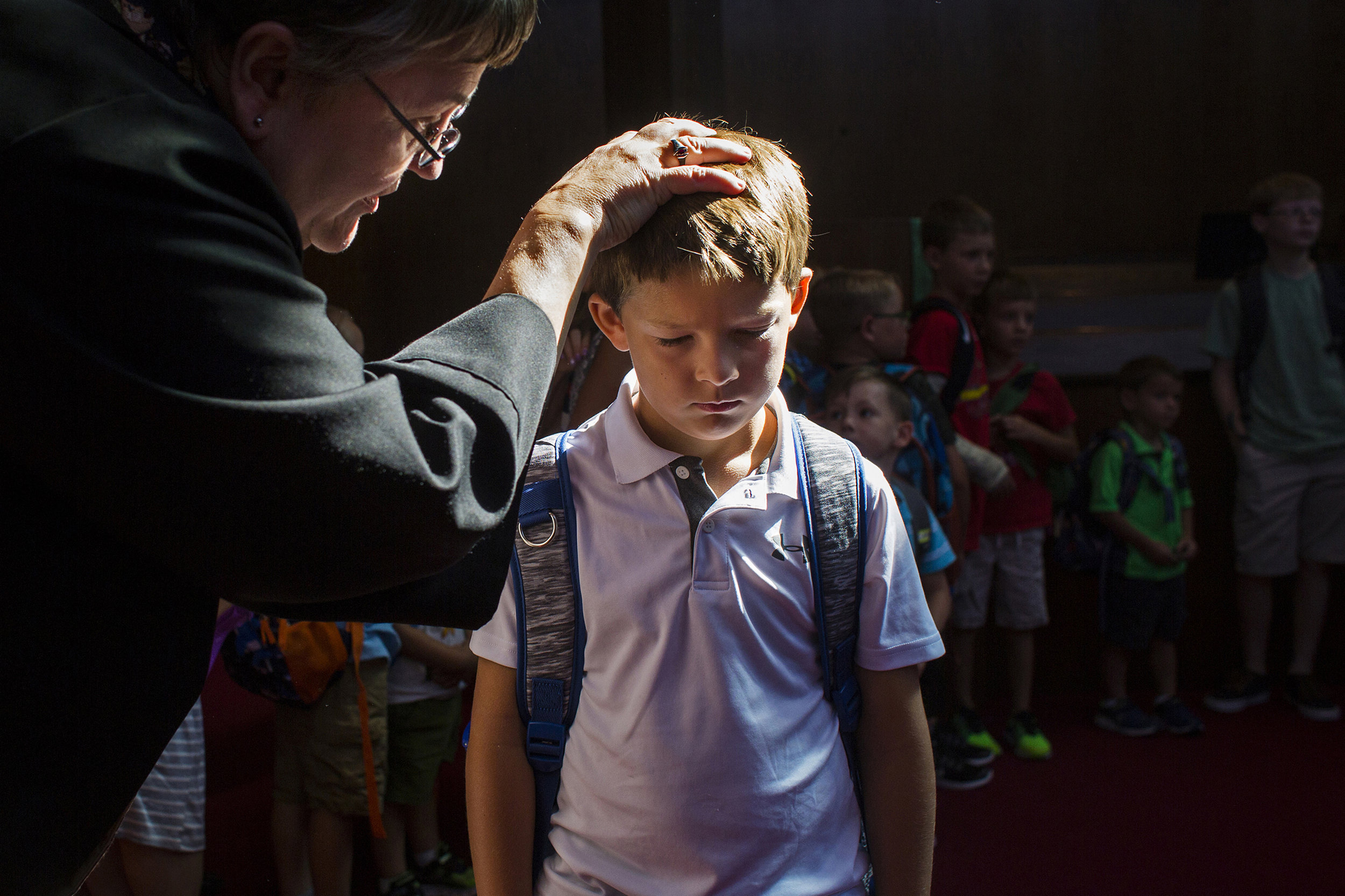 As students process through a blessing of backpacks ceremony at Trinity United Church of Christ's Sunday service, Pastor Jane Hillman says a prayer for Corbin Schnarr of Jasper, 6, on Aug. 13 in Jasper, Indiana. Hillman said she hopes to impart upon