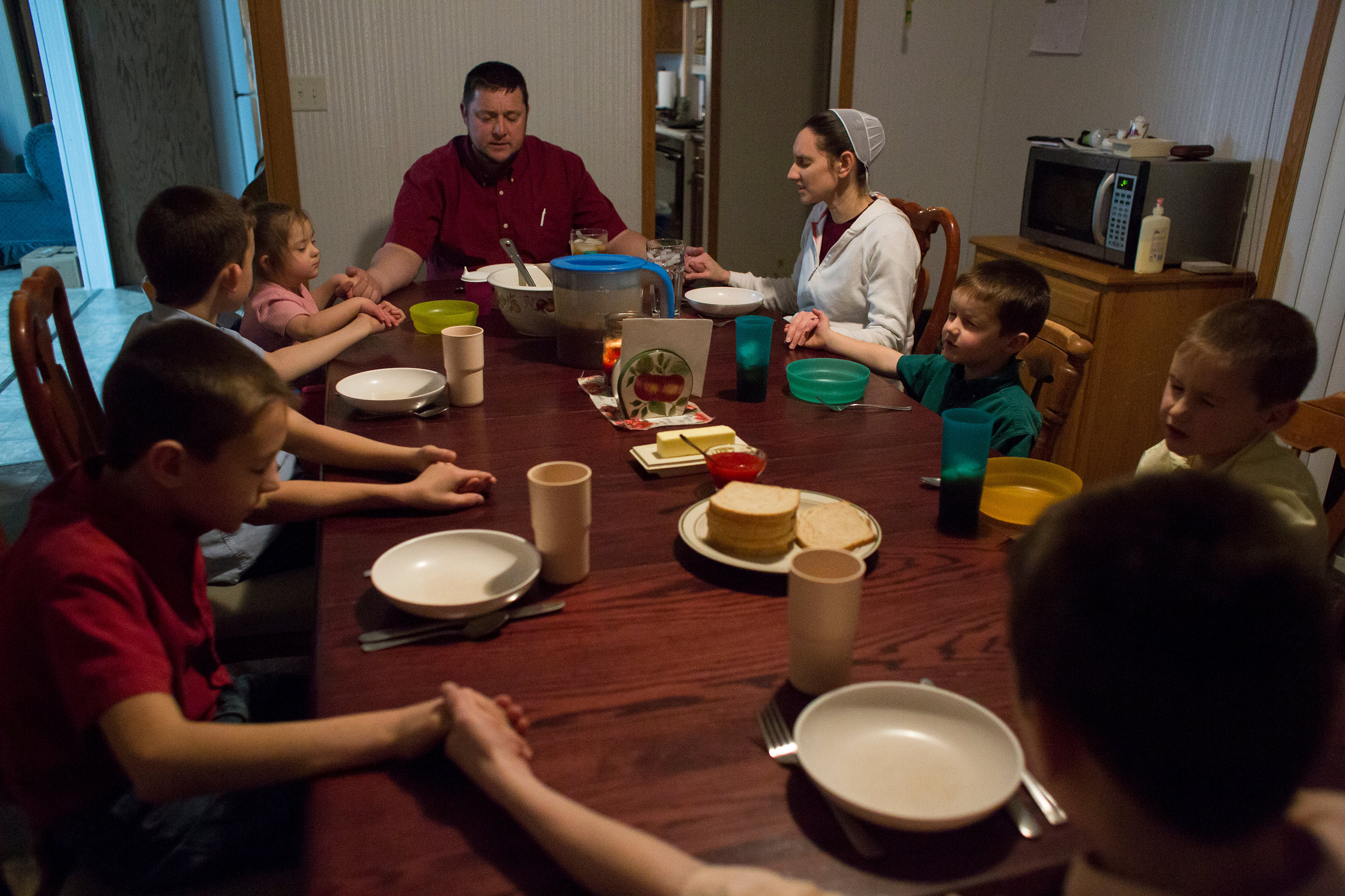  Stanley Knepp along with his wife, Shannon, and their children — Bryant, 12, Cody, 11, Darius, 10, Tyler, 8, Zachary, 5, and Andrea, 3 — sang “Be Present at Our Table” as a song of grace before eating dinner in their Loogootee home Dec. 30. Stanley,