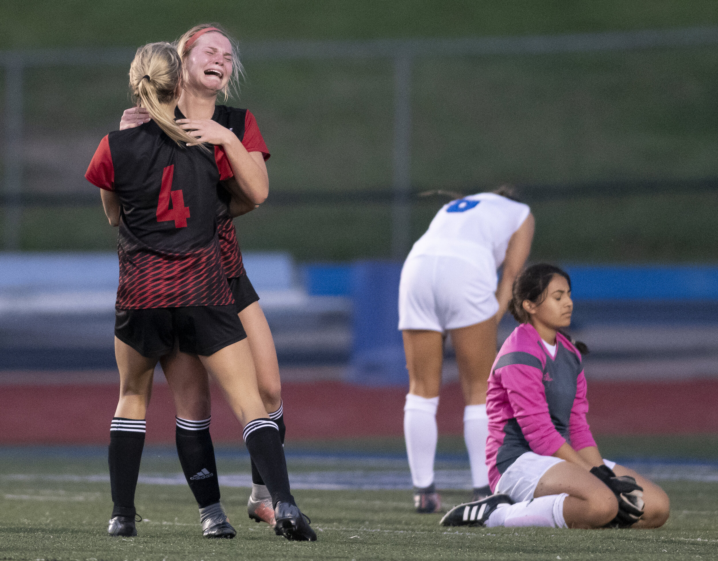  Jackson's Natalie Miller (14) and Katelyn Miller (4), left, celebrate a win as opponents mourn a loss during the Indians' 2-1 double overtime win against Northwest High School in the Class 4 District 1 championship May 15 at Northwest High School in