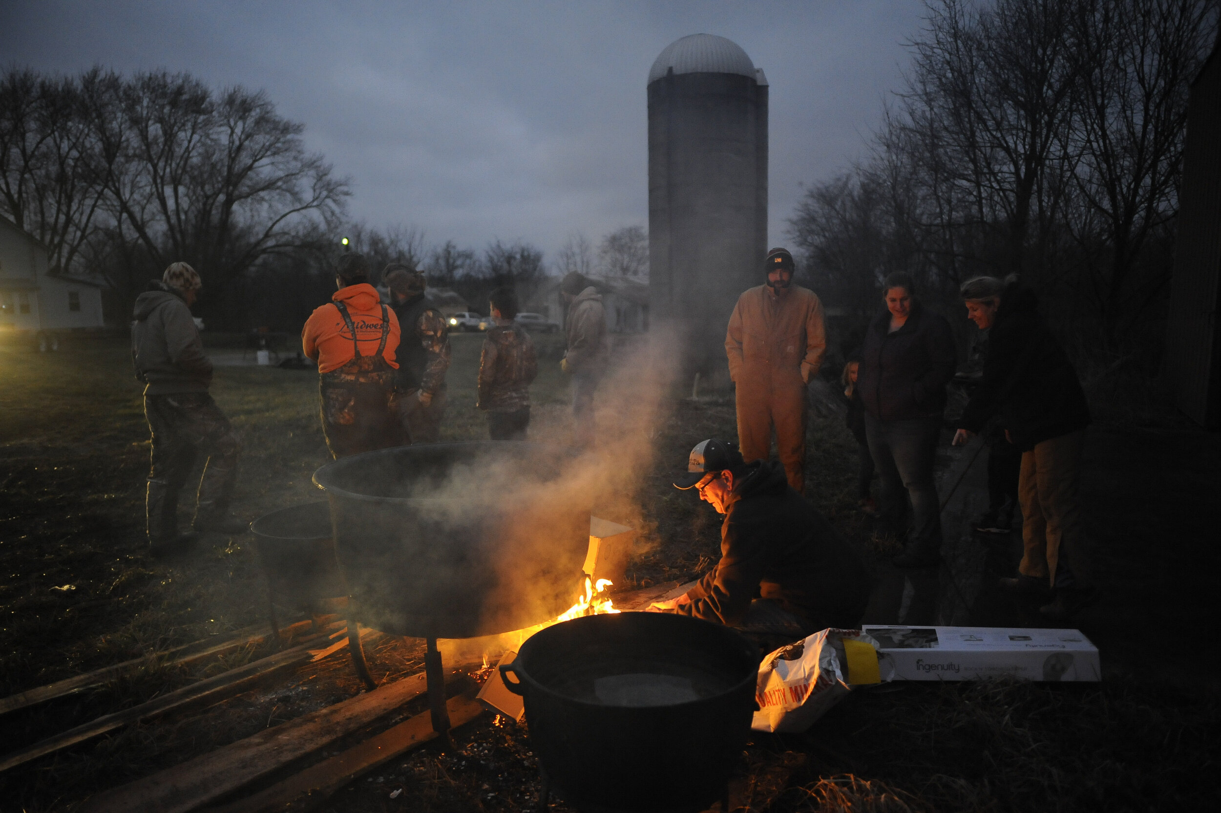  The oldest boy of Rueben Hotop's 13 children, Ronnie Hotop of Perryville, Missouri, lights a fire under a cooking pot shortly prior to 7 a.m. before the start of hog butchering on a farm in rural Perry County, Missouri. 