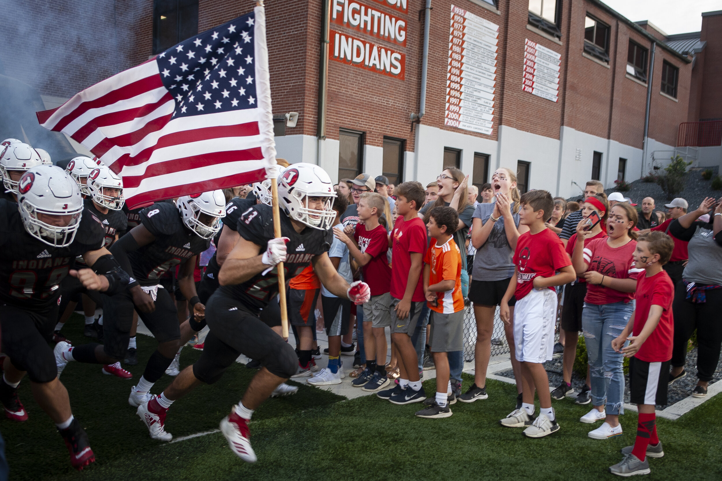  Jackson senior Luke Starzinger (23), with flag, and teammates take the field before the start of the team's 48-0 win against Webster Groves on Friday, Aug. 30, 2019, in Jackson.  